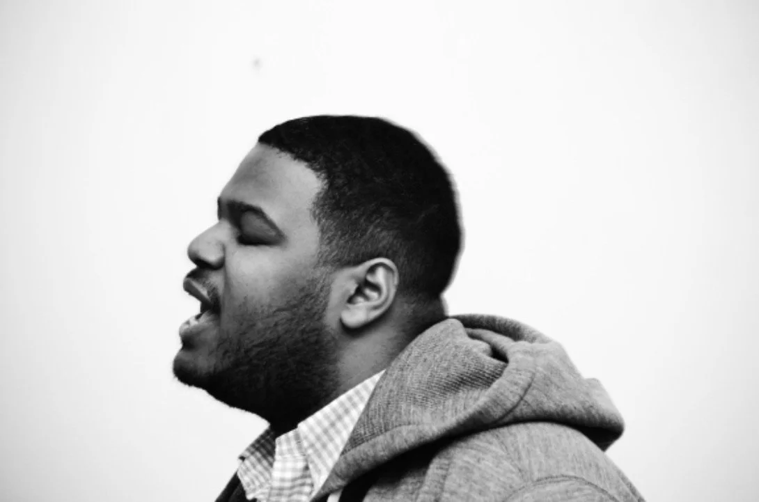 Profile of young black man's face as he opens his mouth to speak