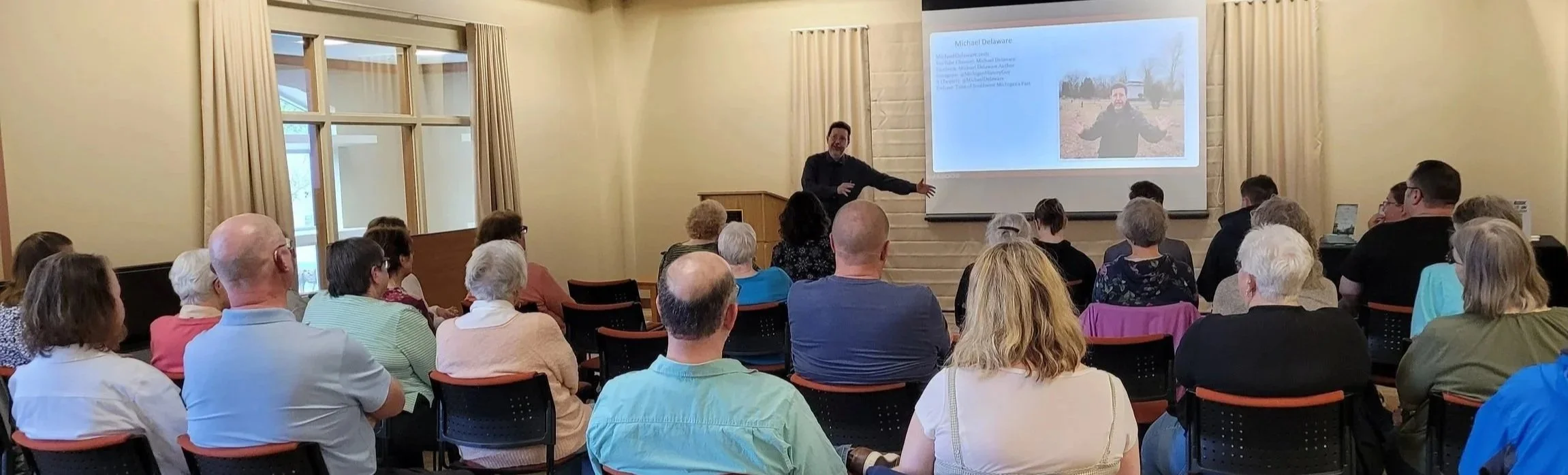 Author Michael Delaware giving a presentation to an audience at a library in Michigan.