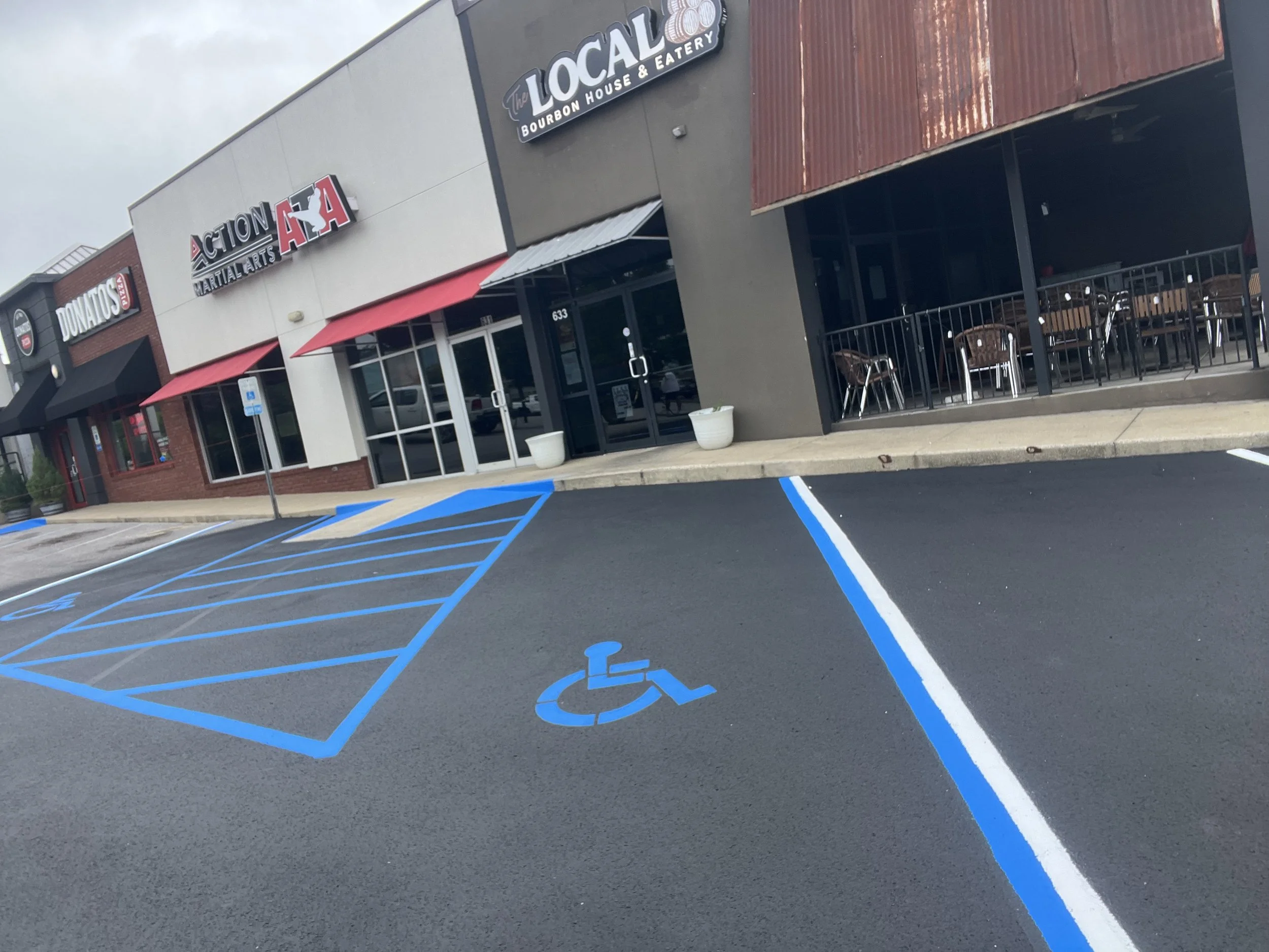 Parking lot with designated blue disabled parking space and space lines.