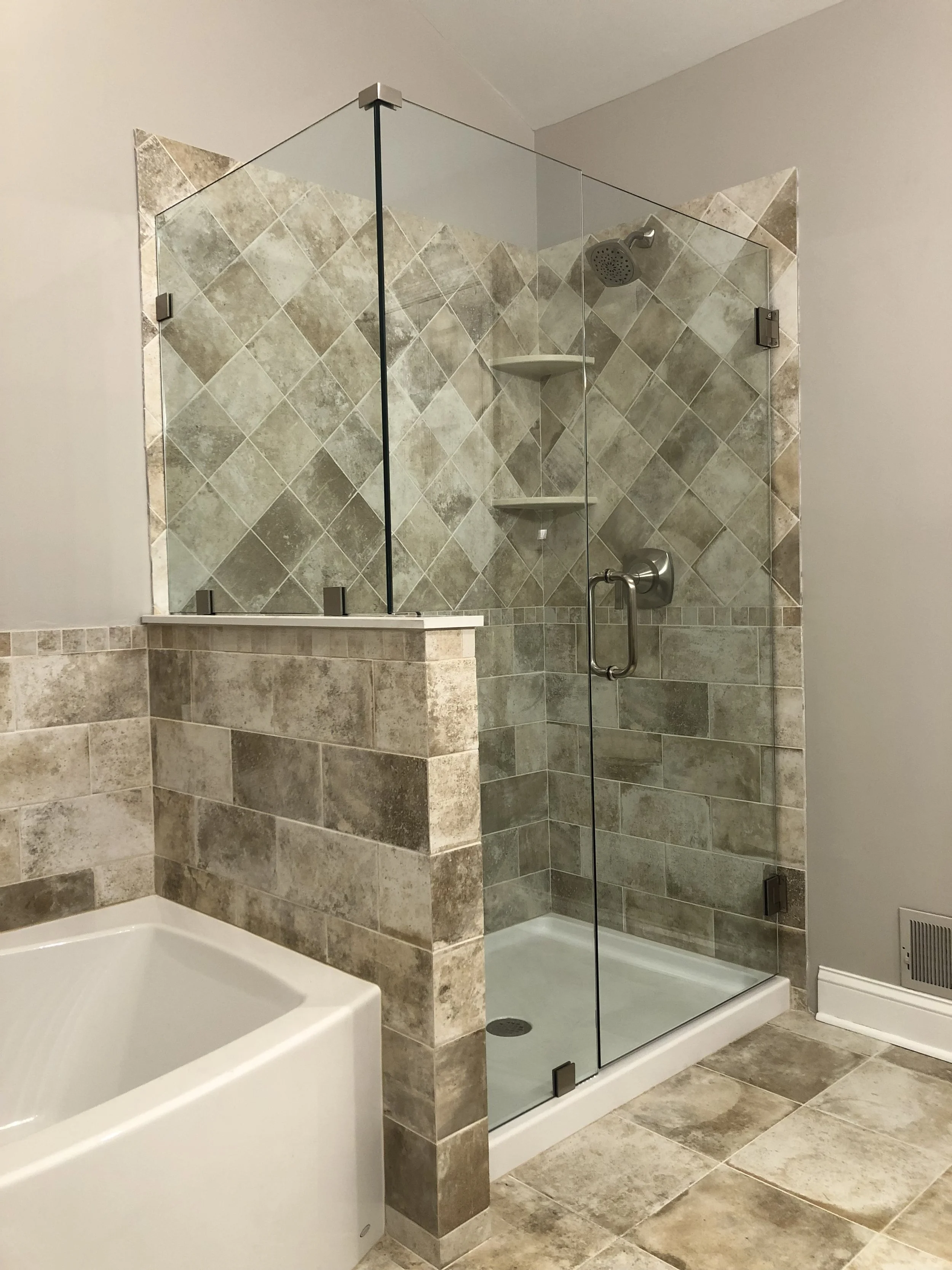 Tiled shower with anchored floating glass enclosure.