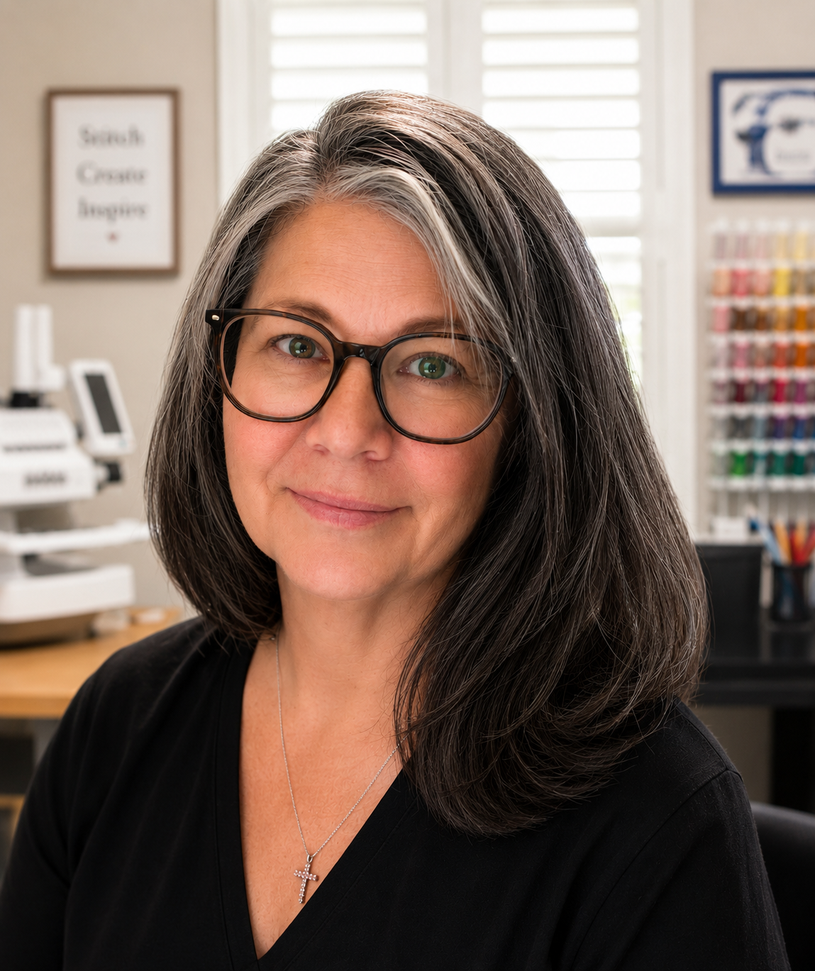 Charlotte Harman of Traveling Stitches smiling in her embroidery workspace.