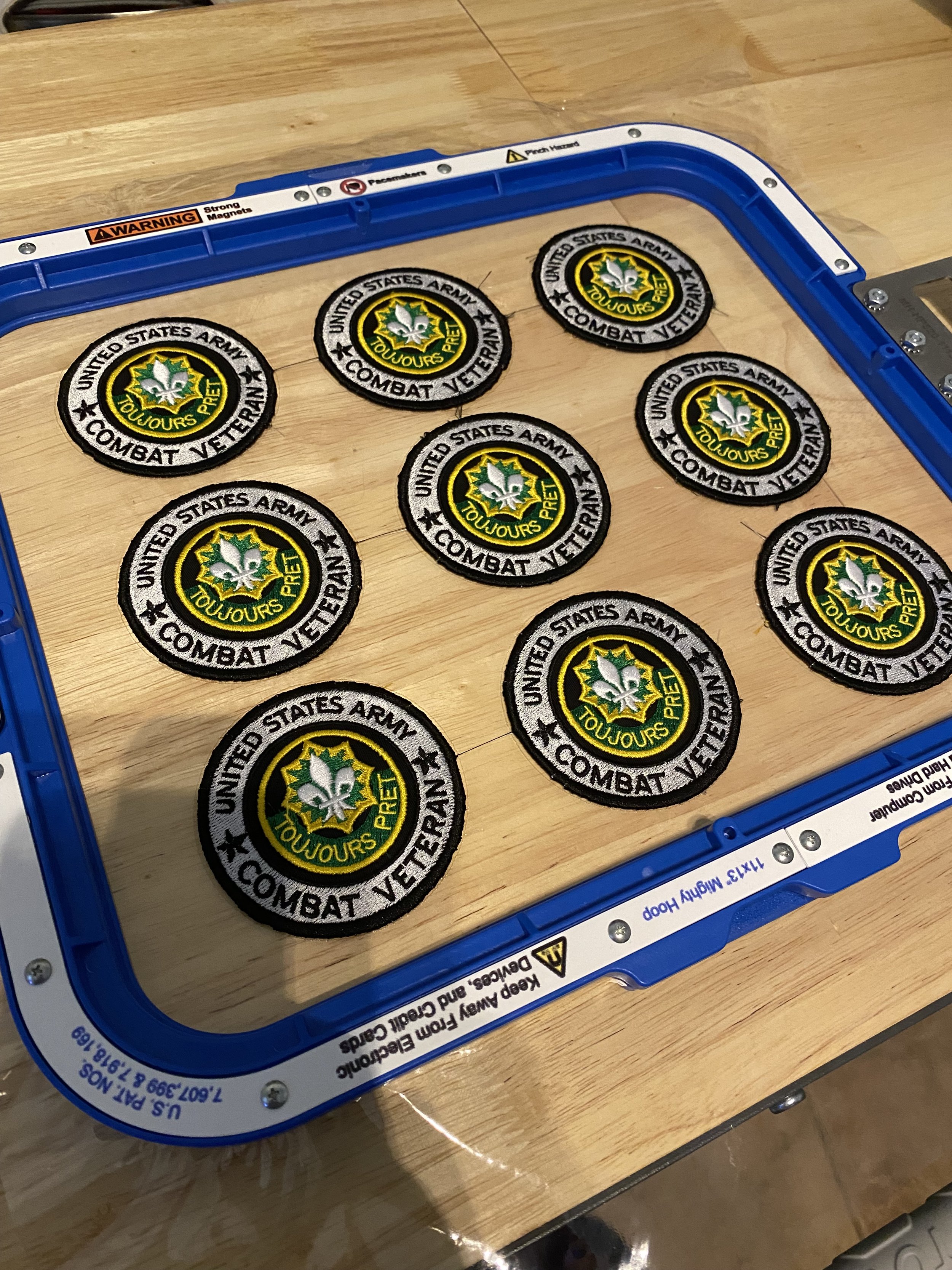 Custom embroidered patches displayed on a wooden table.