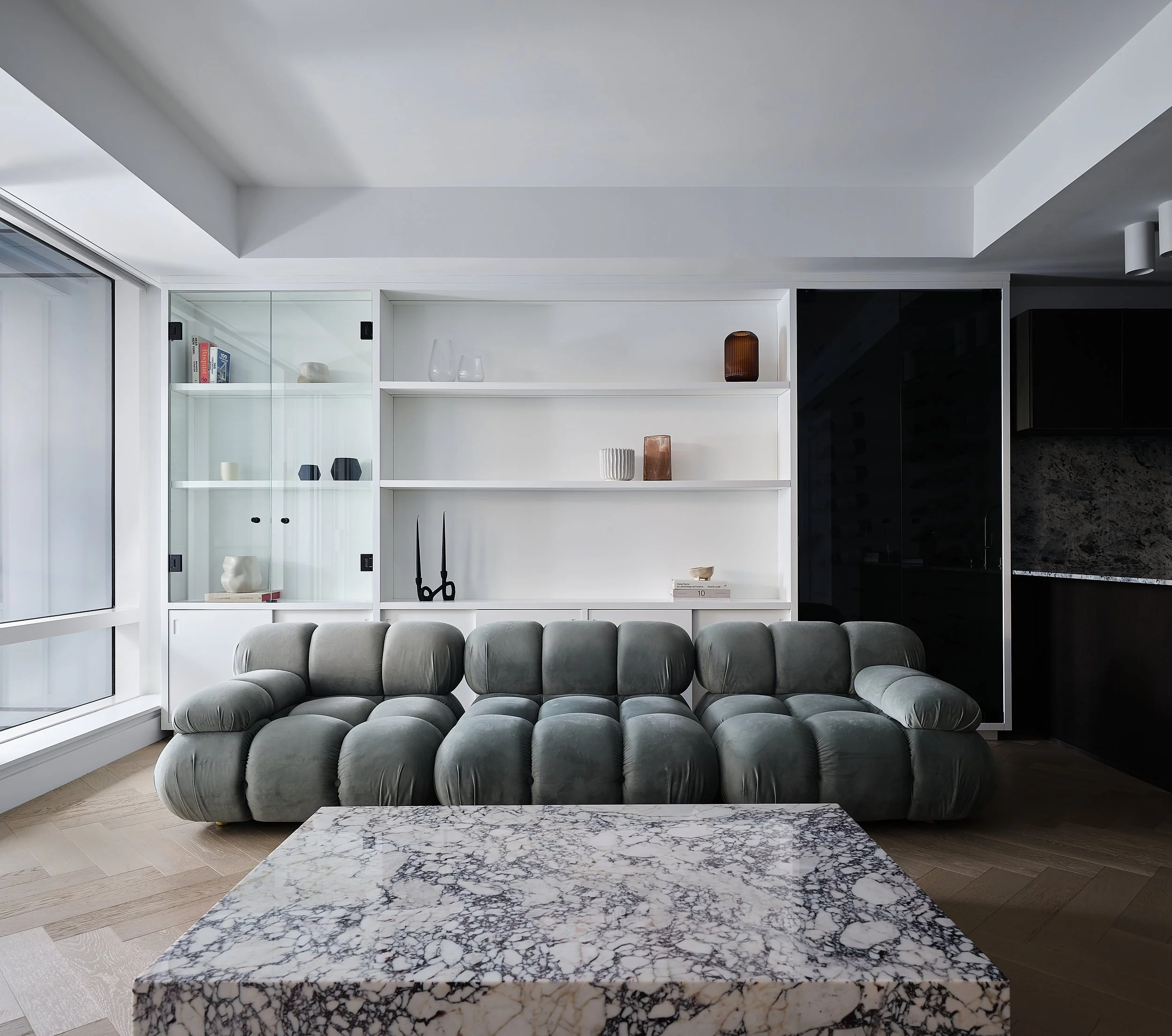 Living room wall system with open shelving and glass-door display cabinets.