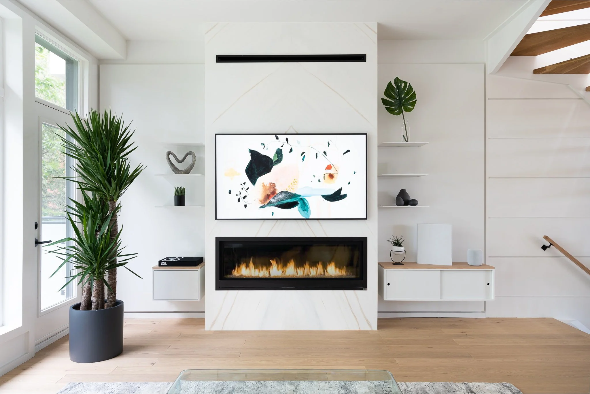 Beach House living room with integrated fireplace, floating cabinetry, and shelving.