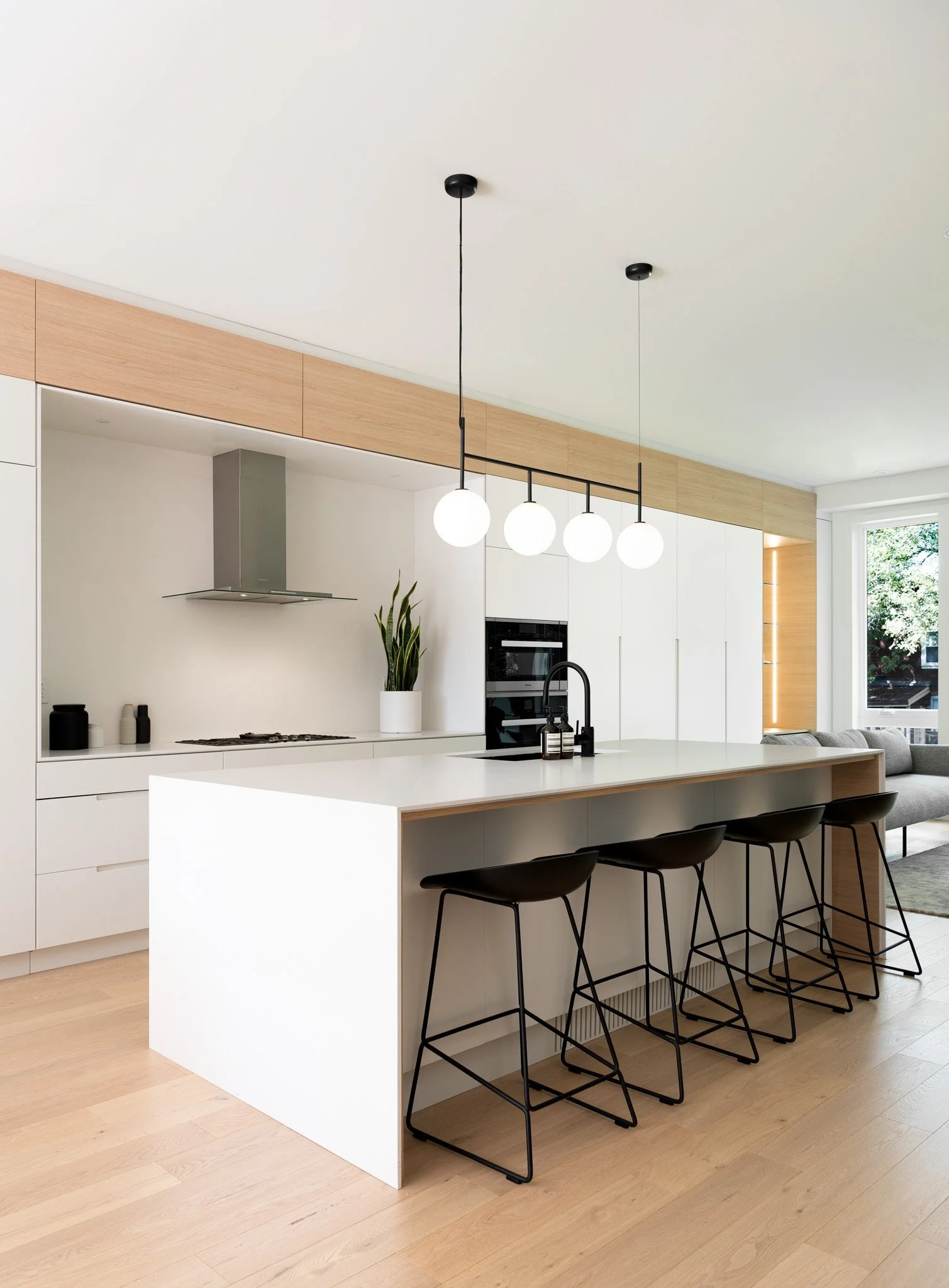 Light-filled Beach House kitchen with full-height cabinetry and a waterfall island by PARVIZ.