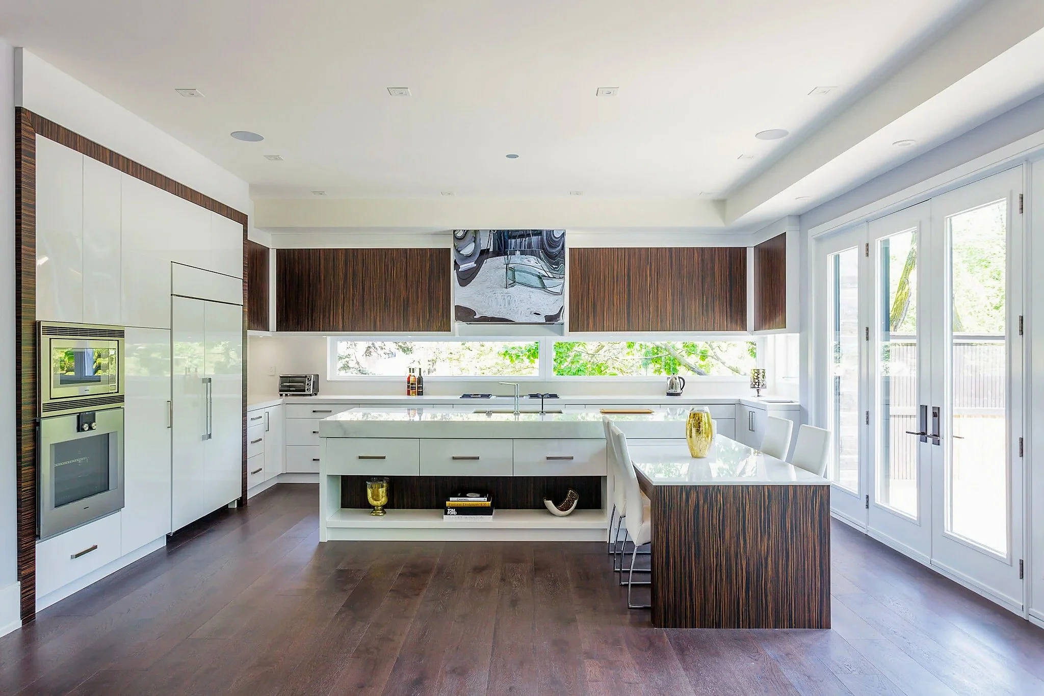 Light-filled Ardmore kitchen with high-gloss white cabinetry and Macassar ebony veneer.