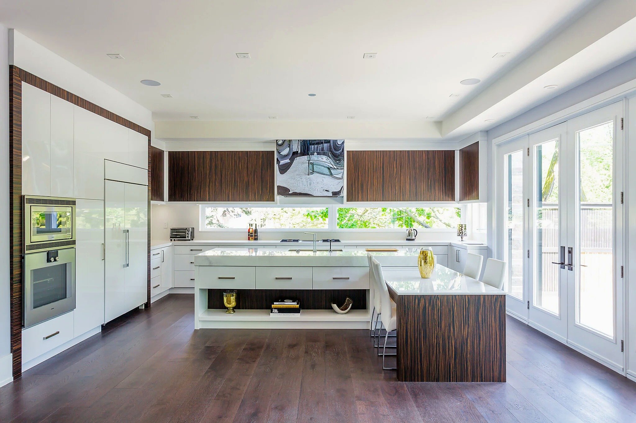 Light-filled Ardmore kitchen with high-gloss white cabinetry and Macassar ebony veneer.