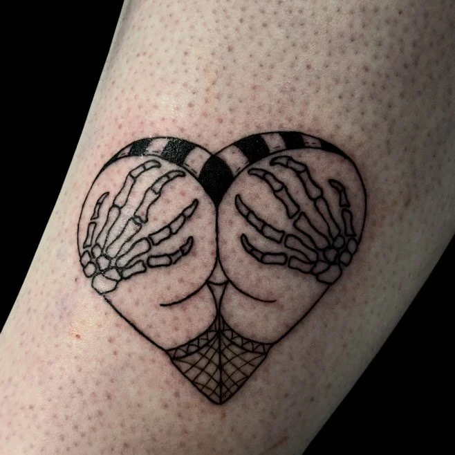Tattoo of two hands forming a heart shape, with skeletal hands inside, and a geometric pattern below.