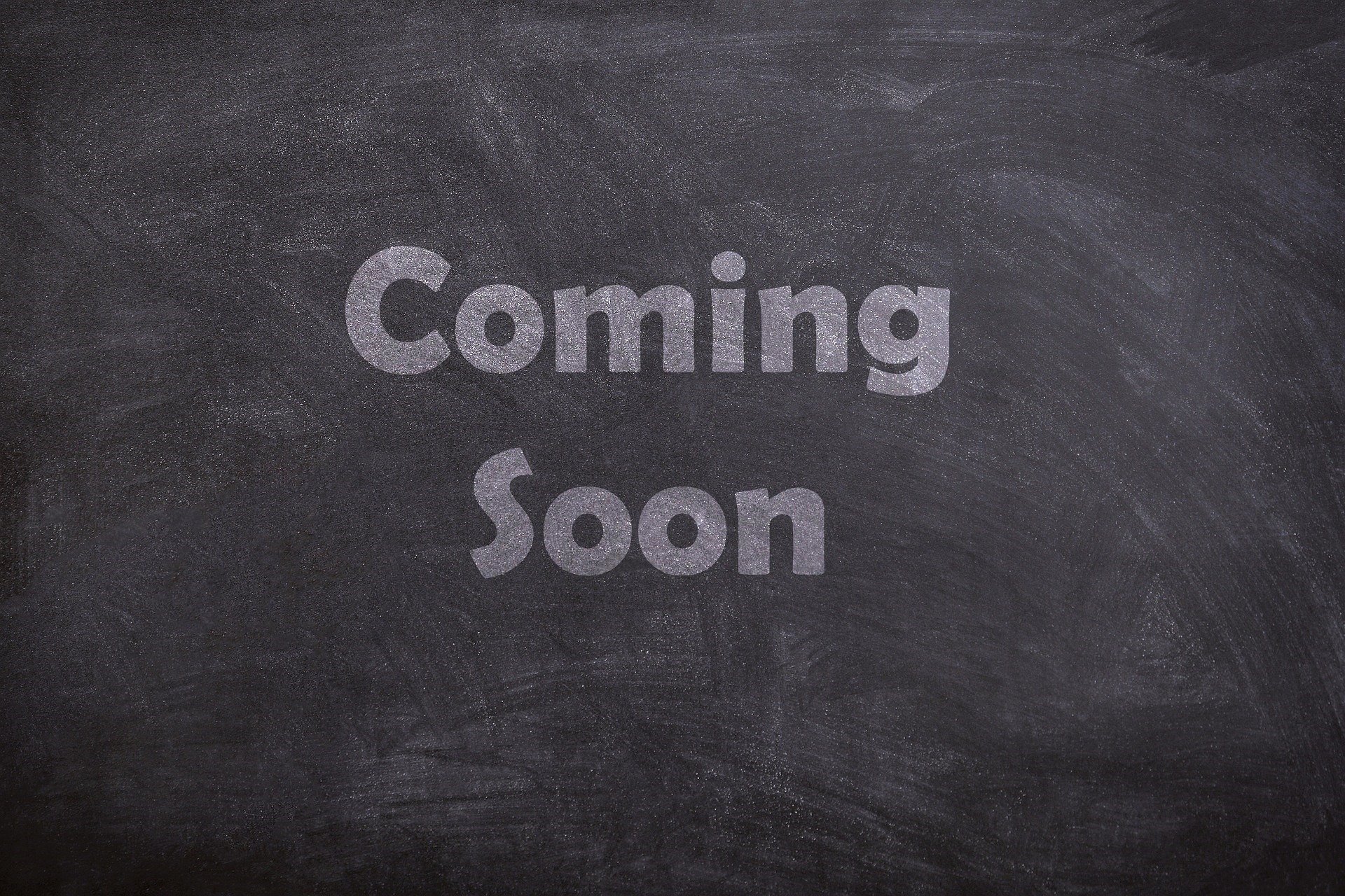 A chalkboard with the words 'Coming Soon' written in large, glittery letters.