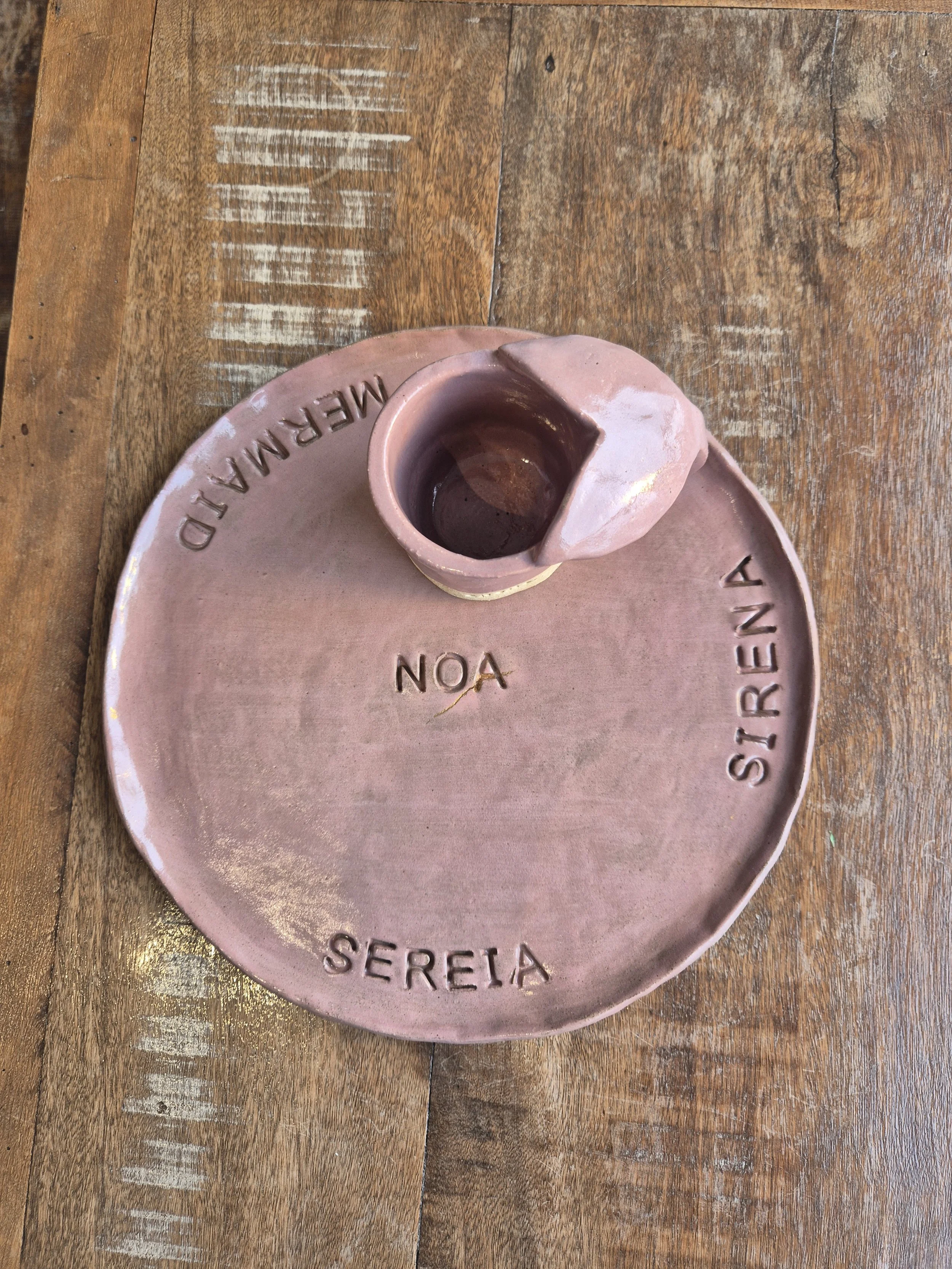Prato de cerâmica rosa com o nome 'Sereia' e uma pequena caneca