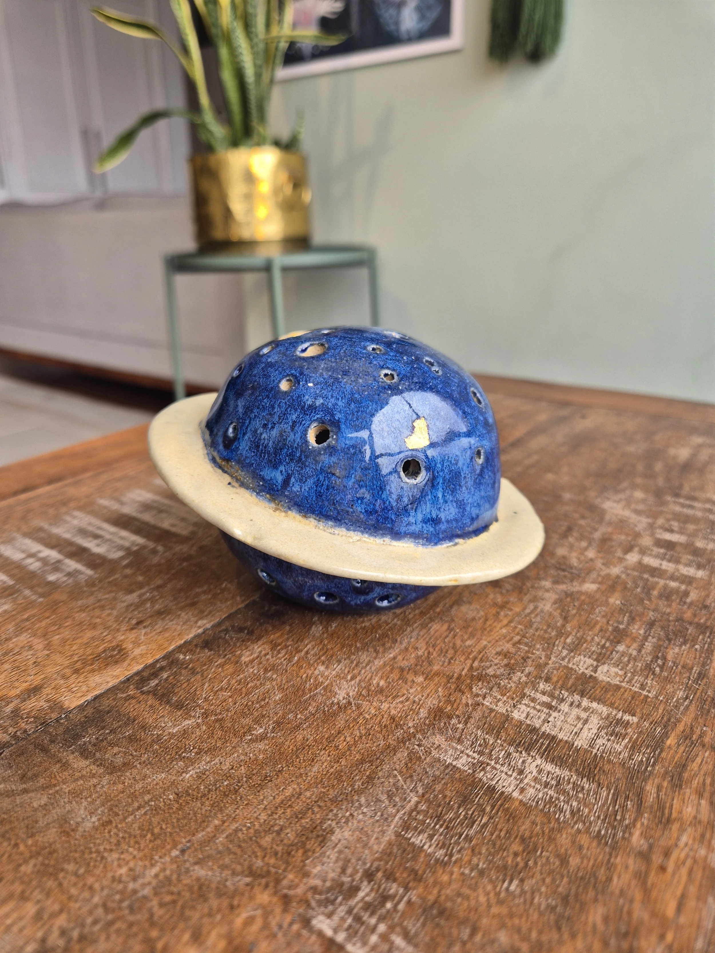 Luminária decorativa em forma de planeta azul com anel dourado ao redor