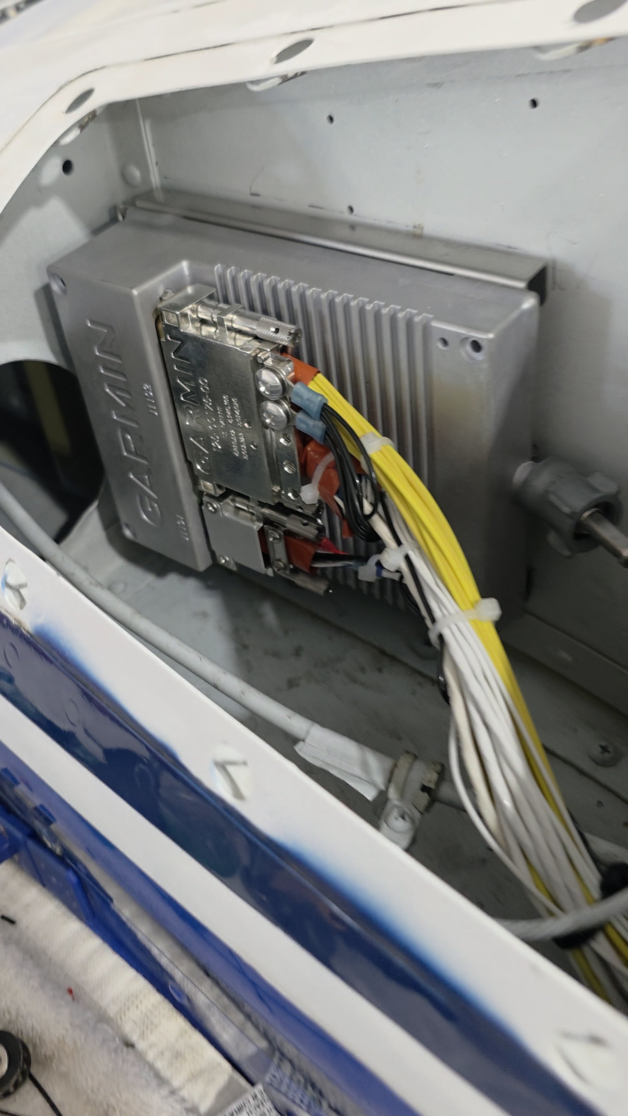 Inside an appliance with a metal control board, cooling fins, and bundled colorful wires.