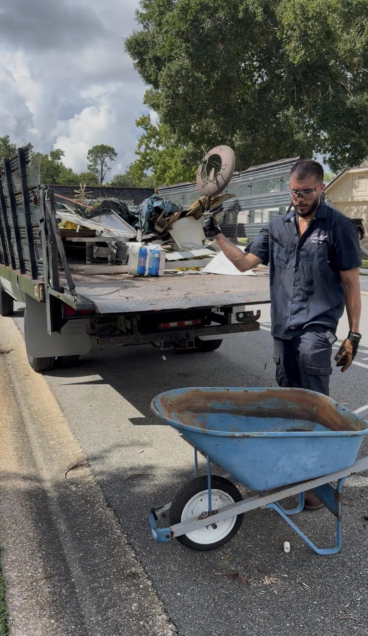Junk removal crew member loading debris into a dump truck during a cleanup job in Orlando, Florida.
