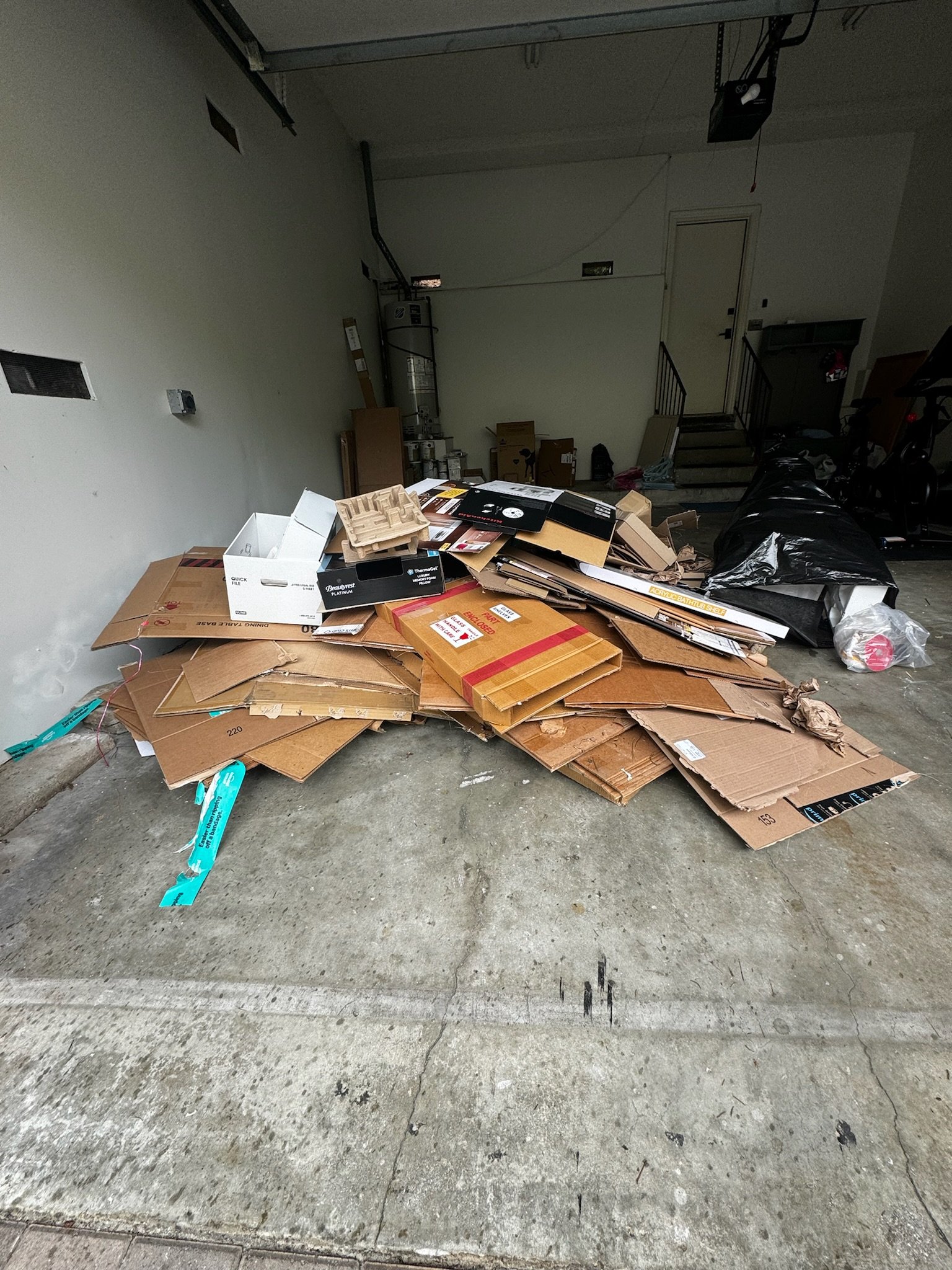 Before photo of a garage cleanout project in Winter Park, FL showing cardboard boxes, packing materials, and household junk before professional junk removal by Coastal Cleanup & Hauling.