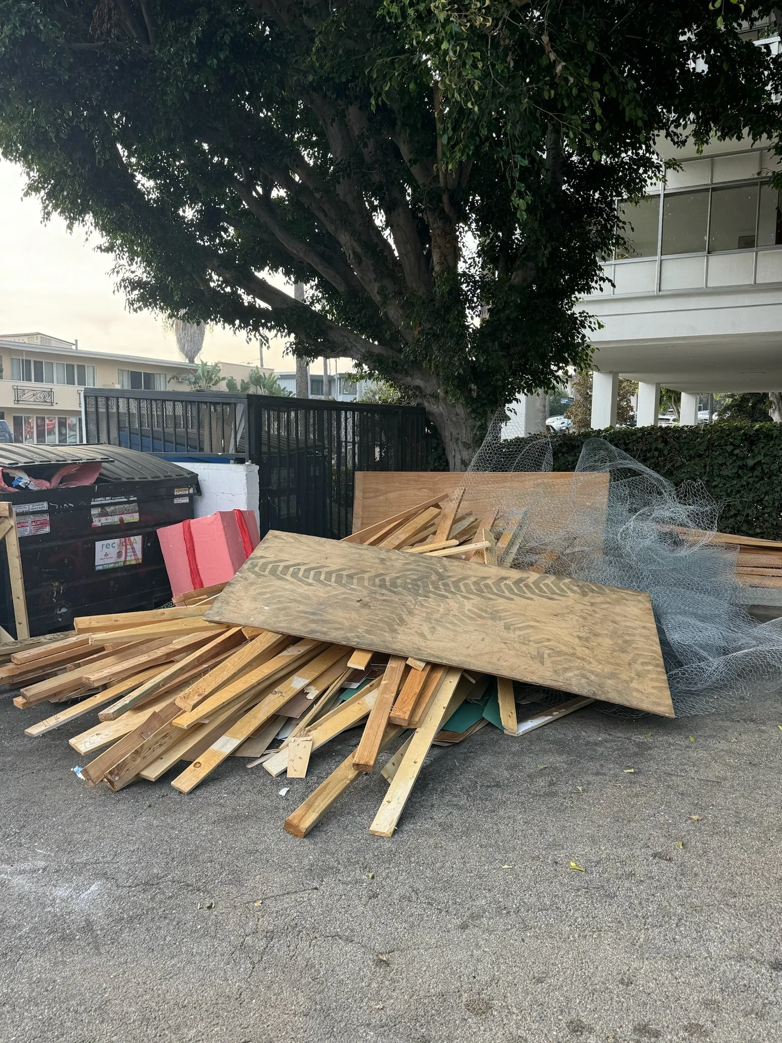 Before photo of a construction debris removal project in Maitland, FL showing lumber, plywood, and demolition materials awaiting pickup by Coastal Cleanup & Hauling.