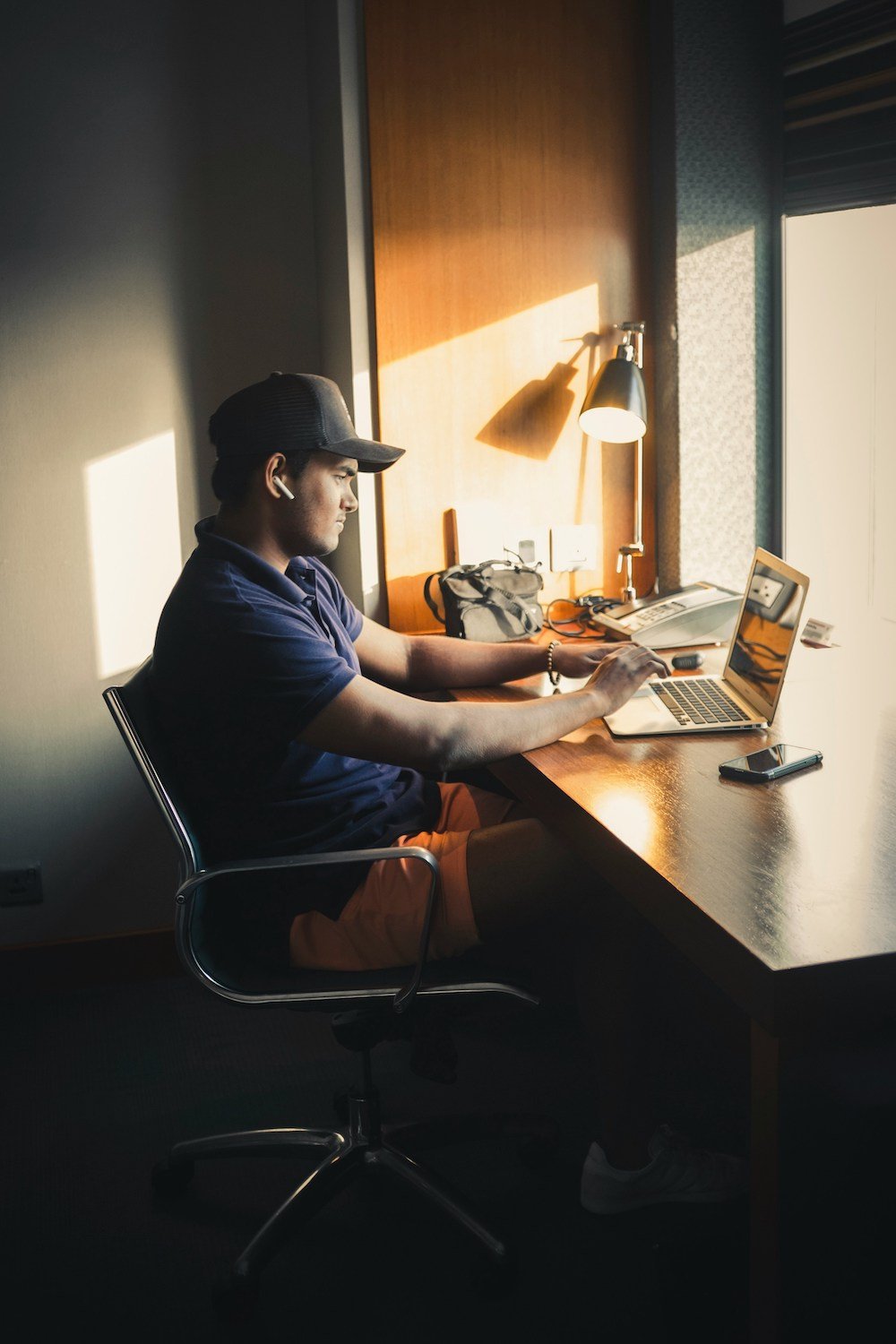 Man working on a laptop by a window