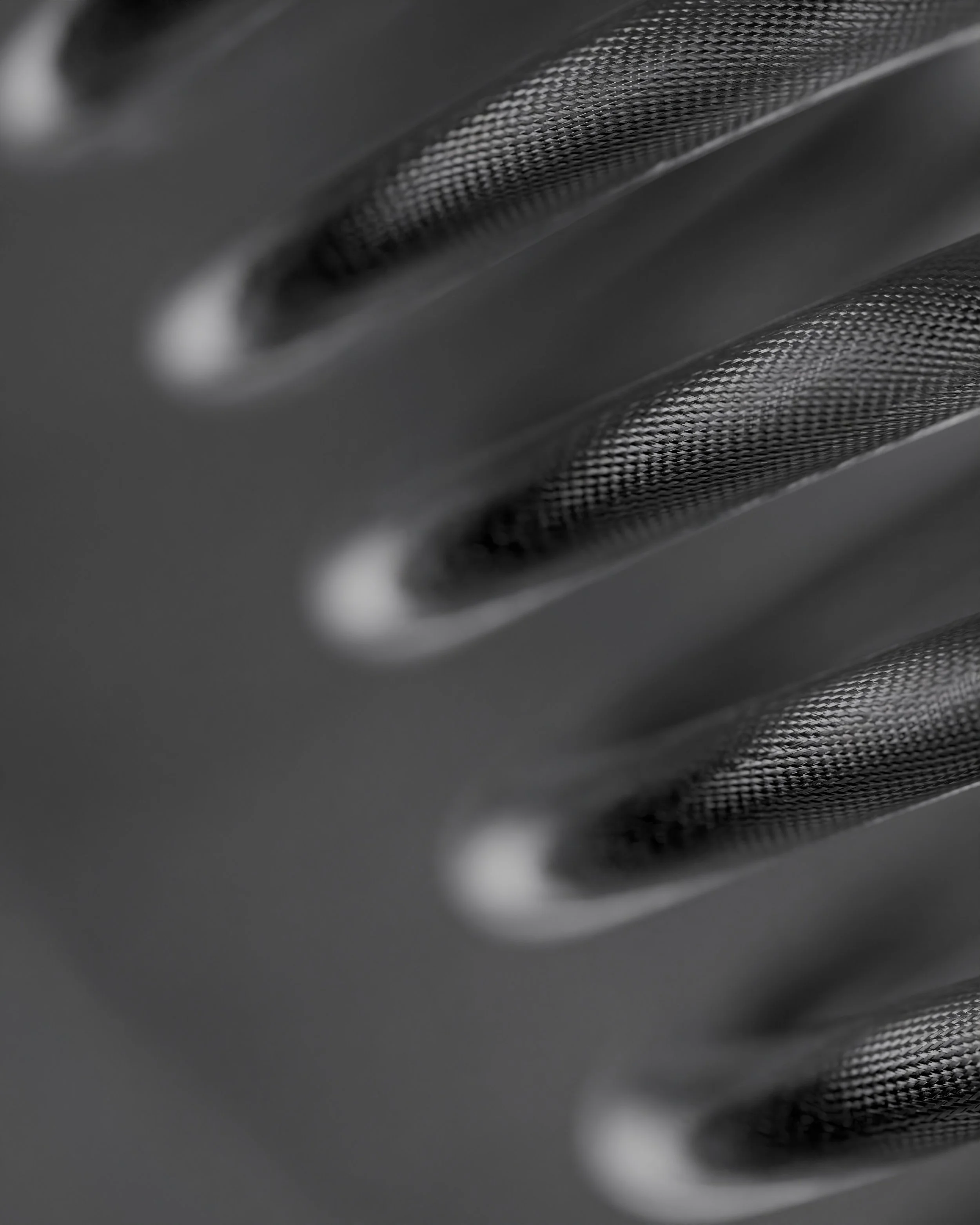 Close-up of a metallic surface with textured holes, possibly part of a mechanical or electronic device.