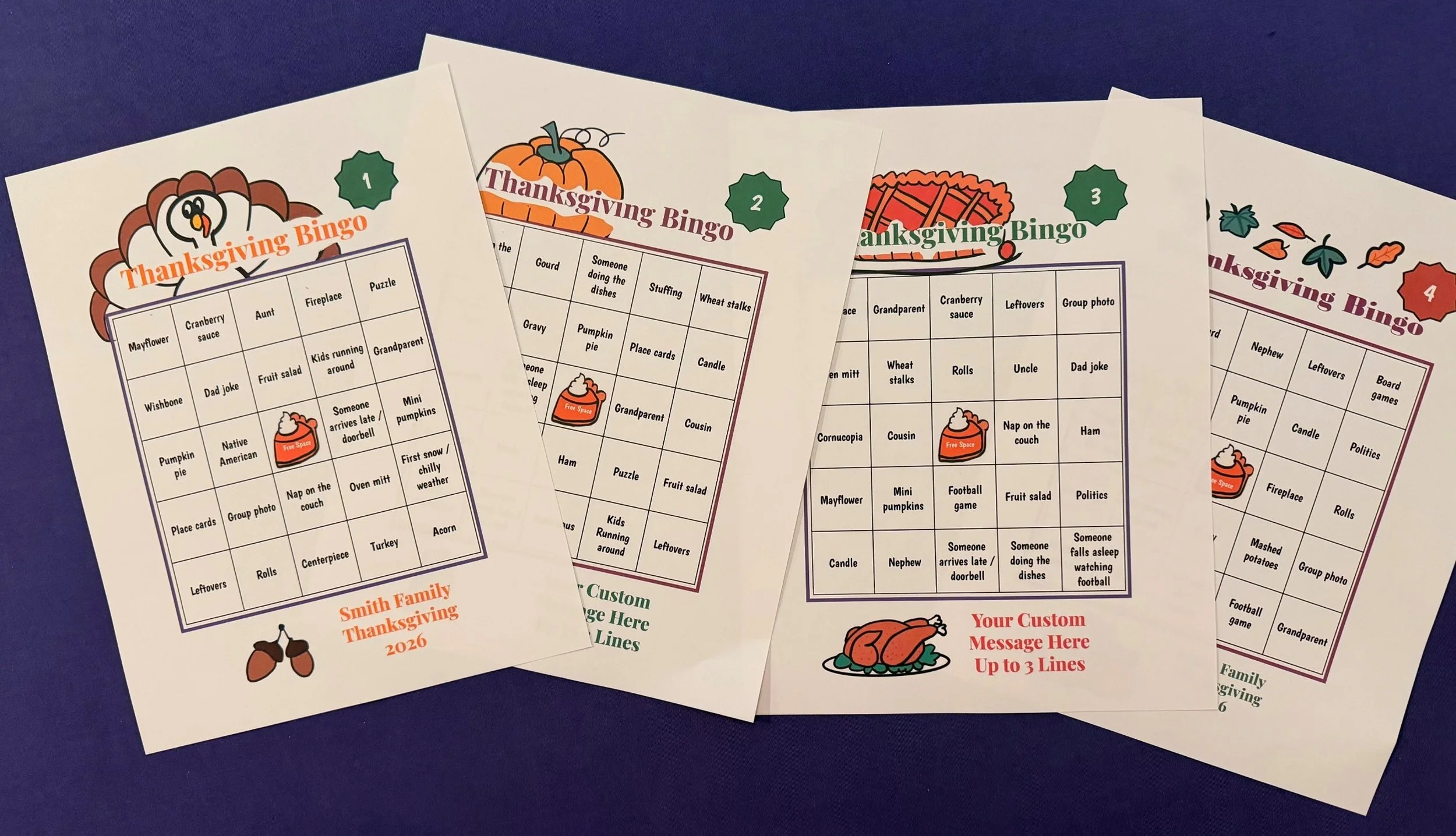 Multiple sheets of Thanksgiving Bingo cards with colorful illustrations of a turkey, pumpkin, and fall leaves, on a dark blue surface.