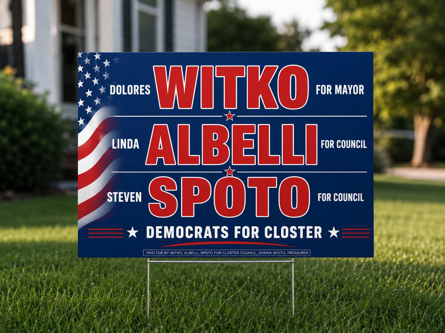 Political campaign yard sign for WITO ALBELLI and SPOTO, Democrats for Closter. The sign has a blue background with red and white text and patriotic decorative elements, and is placed on a lawn with a house and trees in the background.