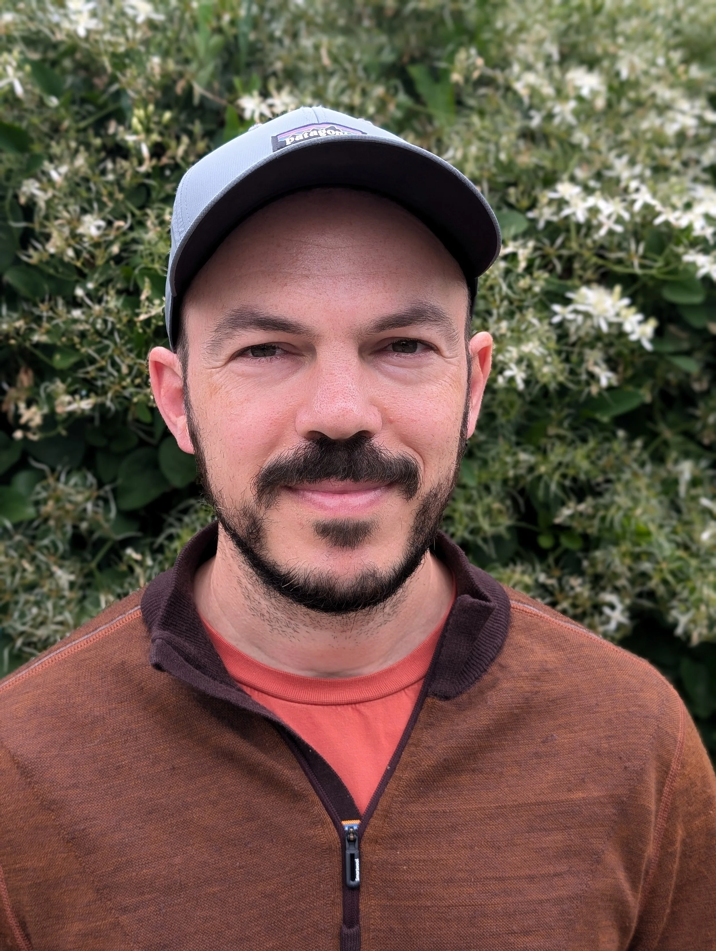 Photo of white man smiling wearing a hat