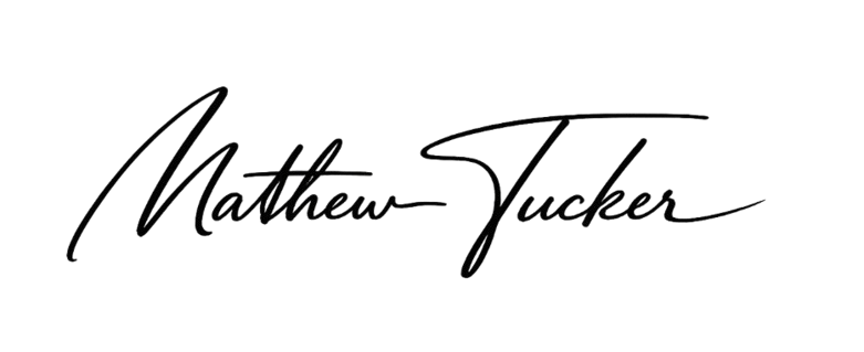 A close-up photo of a black surface with the words 'Matton Yule' written in elegant, cursive handwriting.