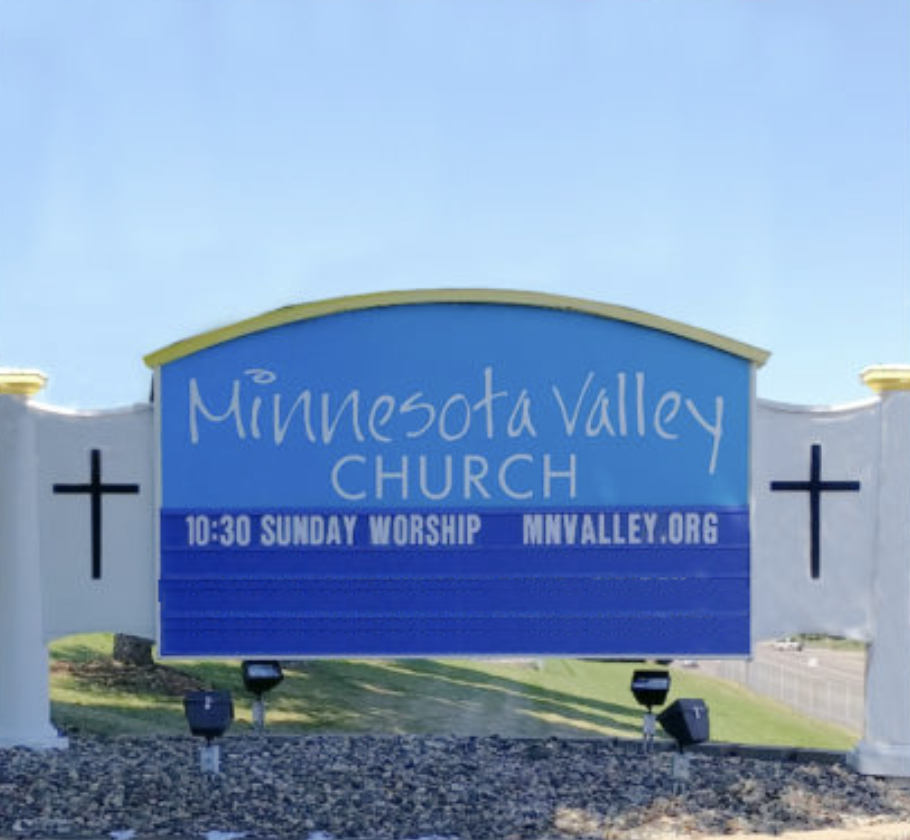 Sign for Minnesota Valley Church with worship time and website information, flanked by two crosses.