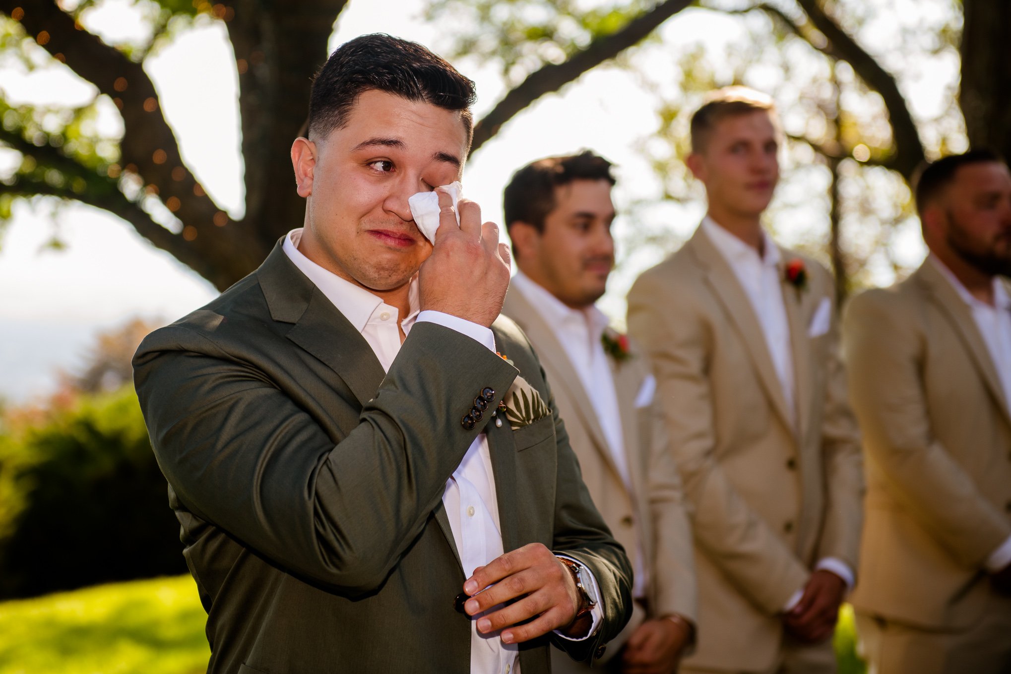 A groom wipes away tears during an emotional outdoor wedding ceremony in Salt Lake City,Utah.