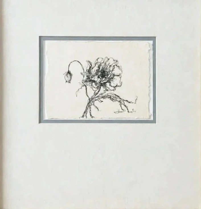 A line drawing of a tree with a street lamp hanging from its branches, displayed in a small picture frame on a white wall.