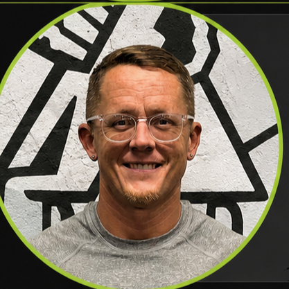 Man with glasses smiling in front of a black and white geometric wall, framed by a green circle.