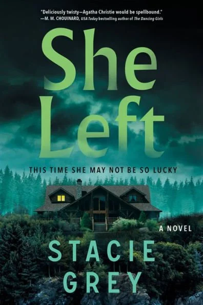 Book cover of 'She Left' by Stacie Grey. The cover features a dark, cloudy sky above a wooded landscape and a house with lit windows.