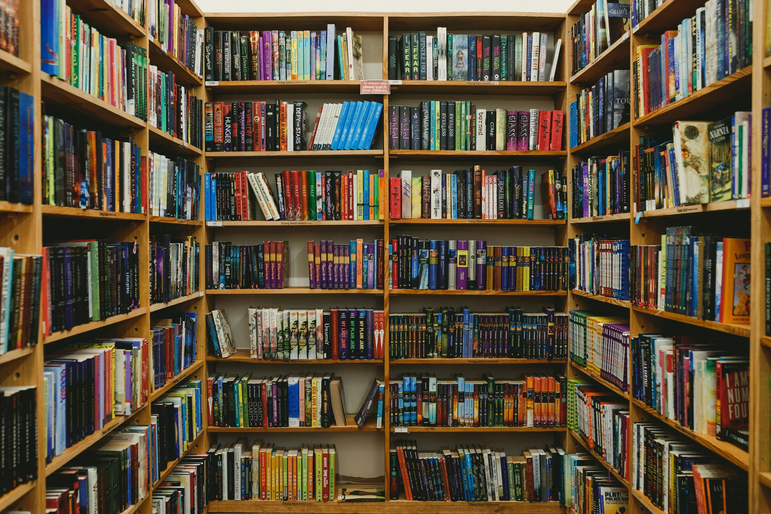 Bookshelves filled with colorful books in a library.