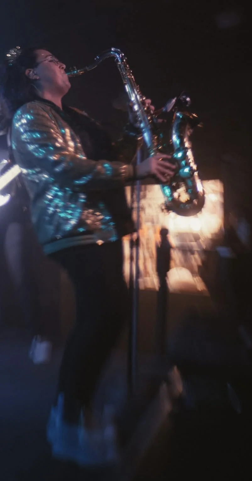 Red House Music and Rehearsal Studio instructor, Tessa O'Boyle playing saxophone on stage with Remember Jones. 