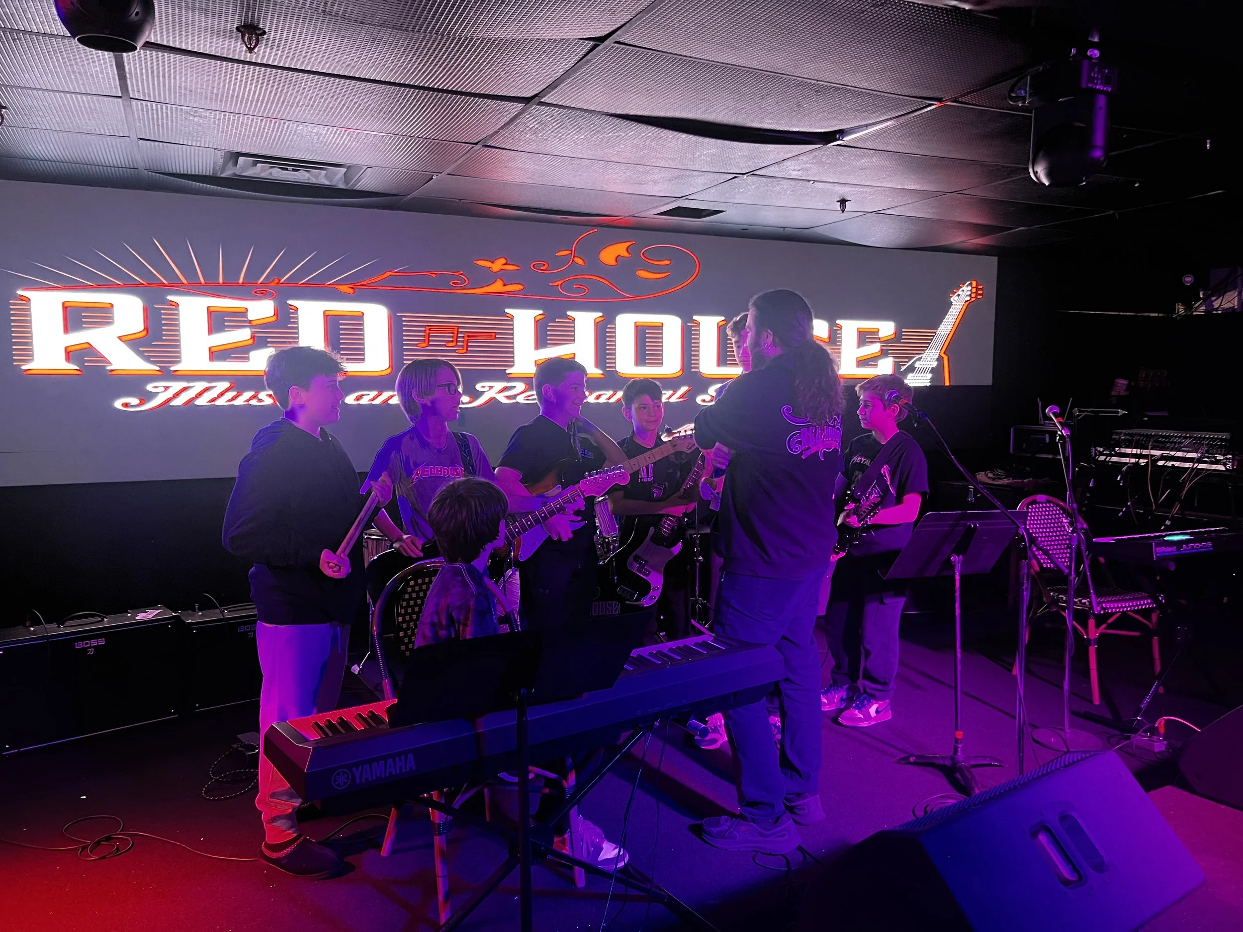 A group of Red House Music and Rehearsal Studio students gather with their instructor before performing at Headliner Nightclub in Neptune, NJ.