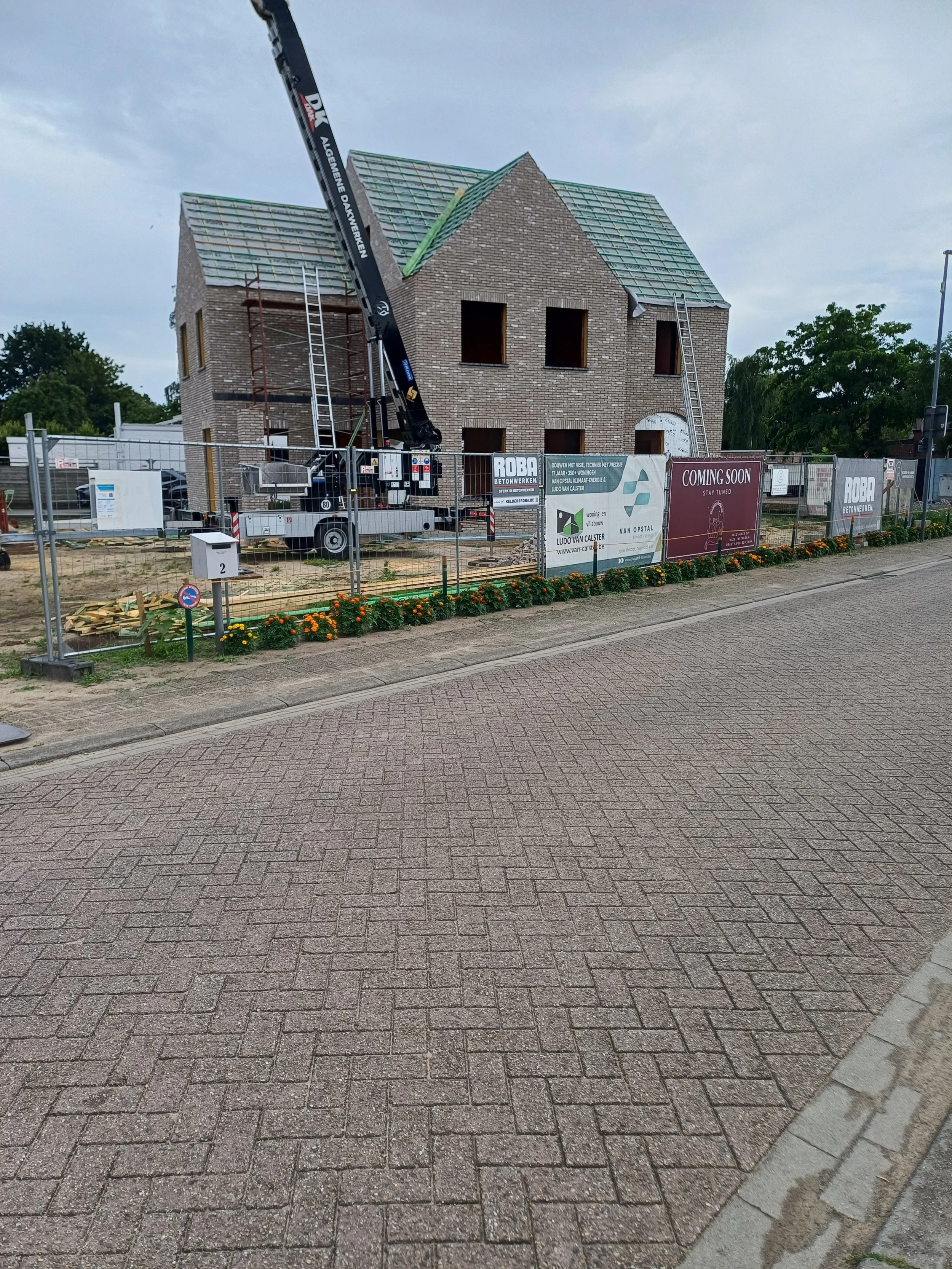 Een huis dat wordt gebouwd met een bakhuis en een betonnen dak met houten balken.