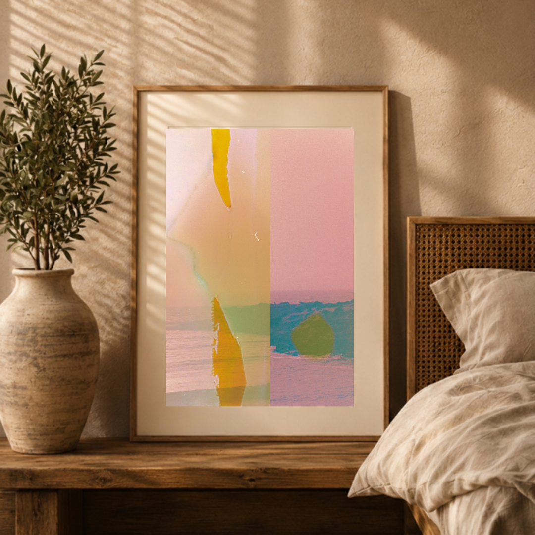 Photograph of a bedroom with a wooden bedside table, a large framed artwork featuring pastel colors, a potted plant in a textured beige vase, and a bed with beige bedding. Sunlight casts shadows on the wall.