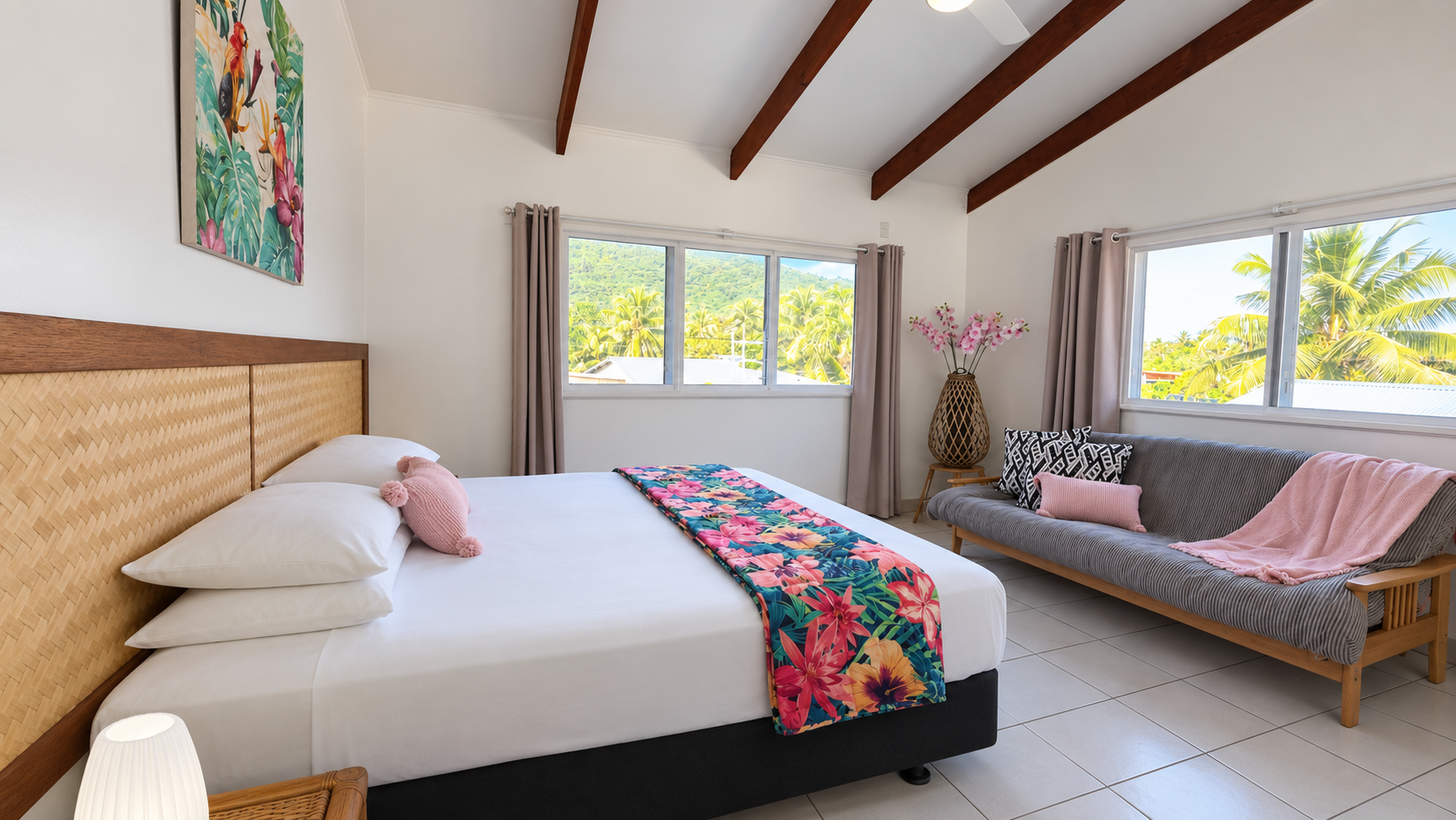 Comfortable bedroom with tropical decor at Arorangi Sunset Beach House