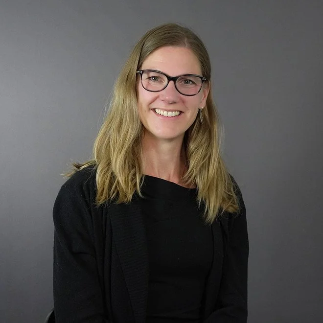 Foto av Ingrid Aarnes med svart topp, langt hår og briller.