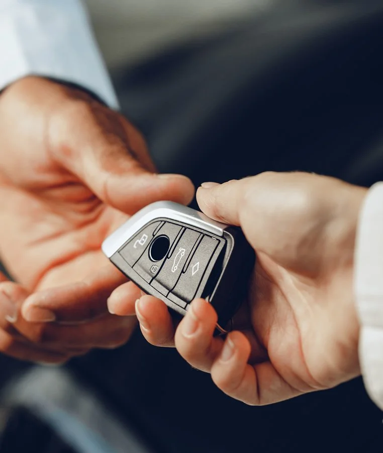 Close-up of a person's hands holding a car remote key fob.