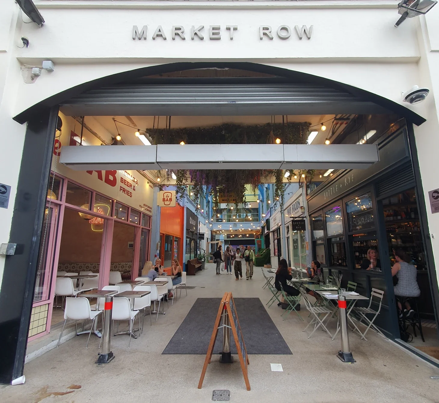 A photo showing an outside entrance of Brixton Village which says "Market Row"