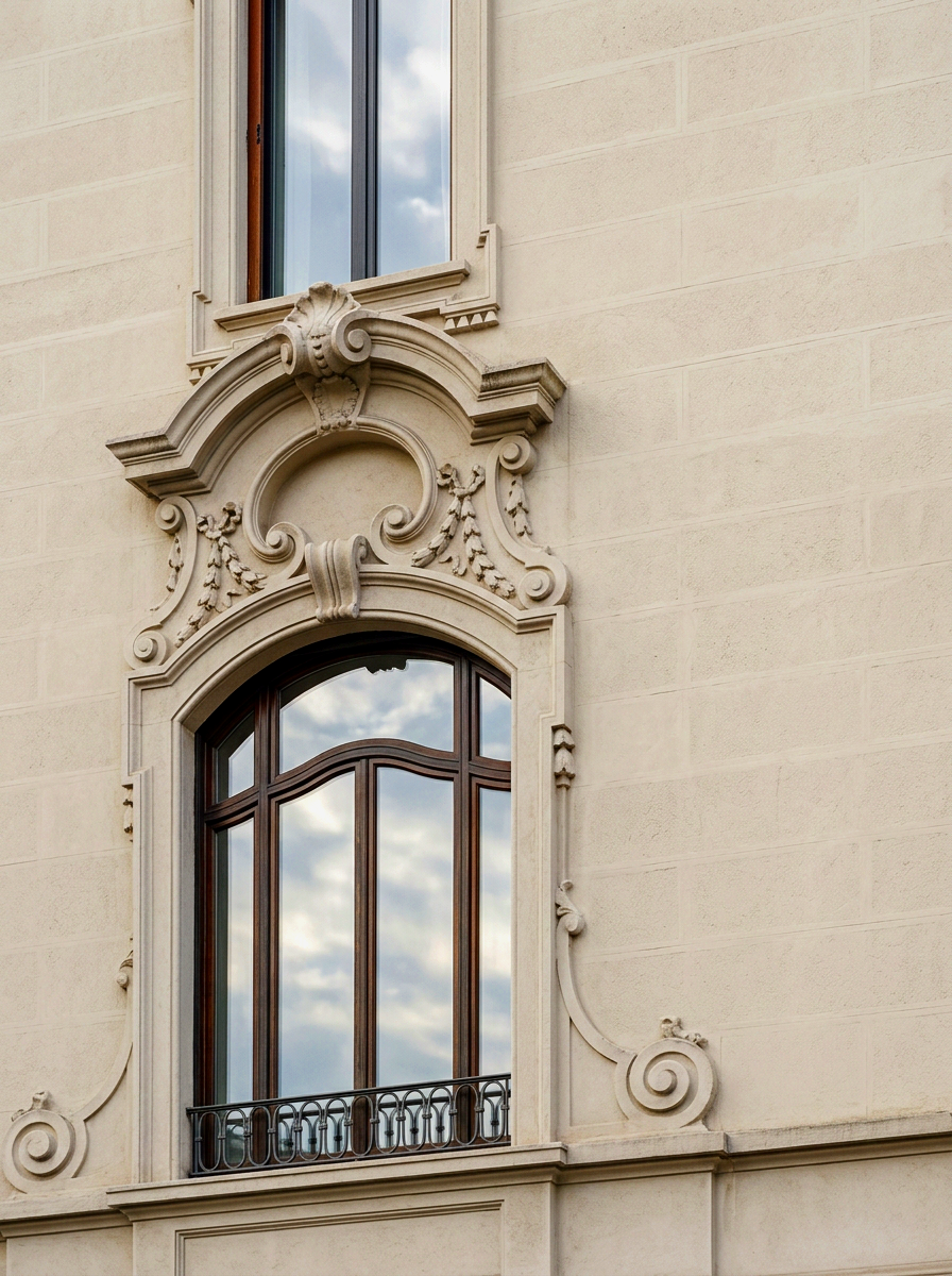 Finestra di un edificio storico con decorazioni in stile Barocco, riflesso del cielo con nuvole nel vetro.