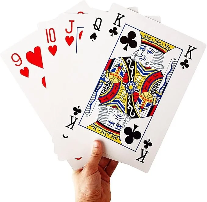 A person holding five playing cards: 10 of hearts, 9 of hearts, Jack of hearts, Queen of spades, and King of clubs.