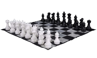 A chessboard with black and white chess pieces arranged for a game.