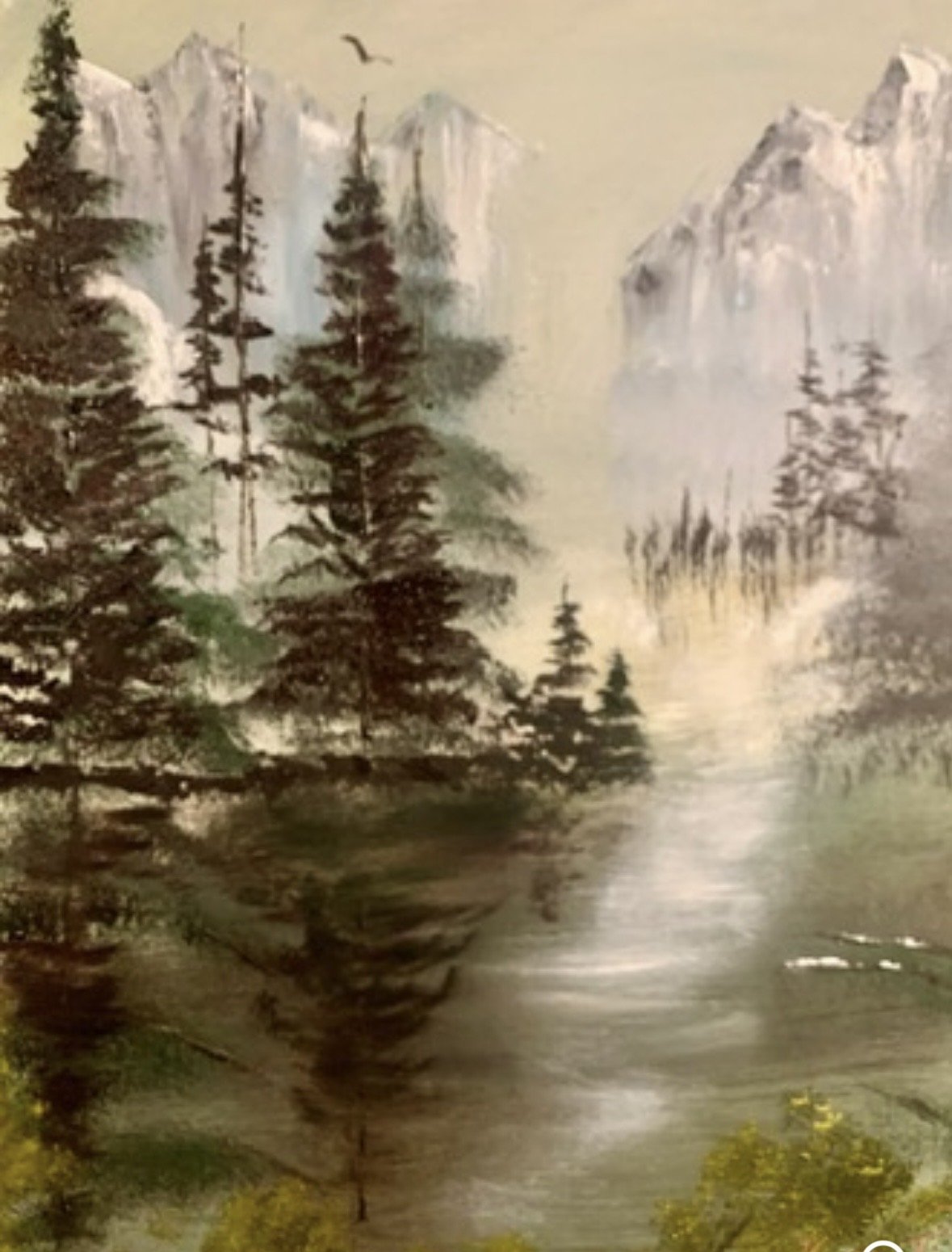 Mountain Serenity invites the viewer into a quiet alpine valley where mist rises gently from still waters beneath towering snow-capped peaks. Evergreen forests frame the landscape while soft morning light fills the valley with warmth and hope. The pa