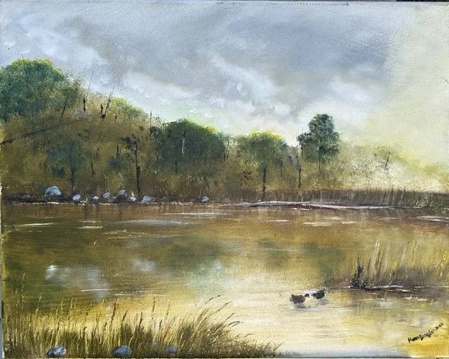 Golden Reflections captures the quiet beauty of evening as warm light settles across the water and the landscape is bathed in a gentle glow. The stillness of the shoreline and the mirrored reflections invite the viewer to pause, breathe, and find pea