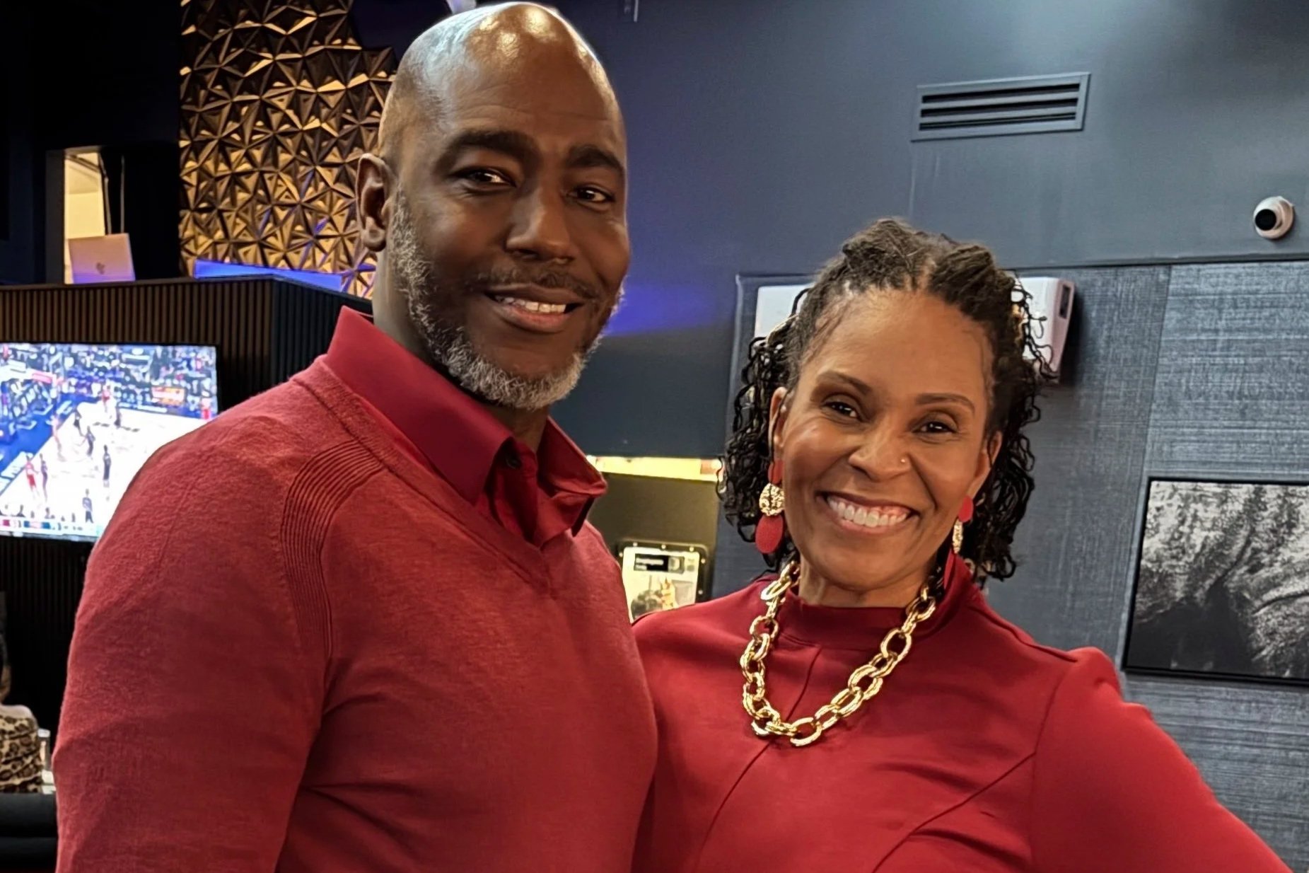 Smiling couple in red clothing posing inside a recording studio