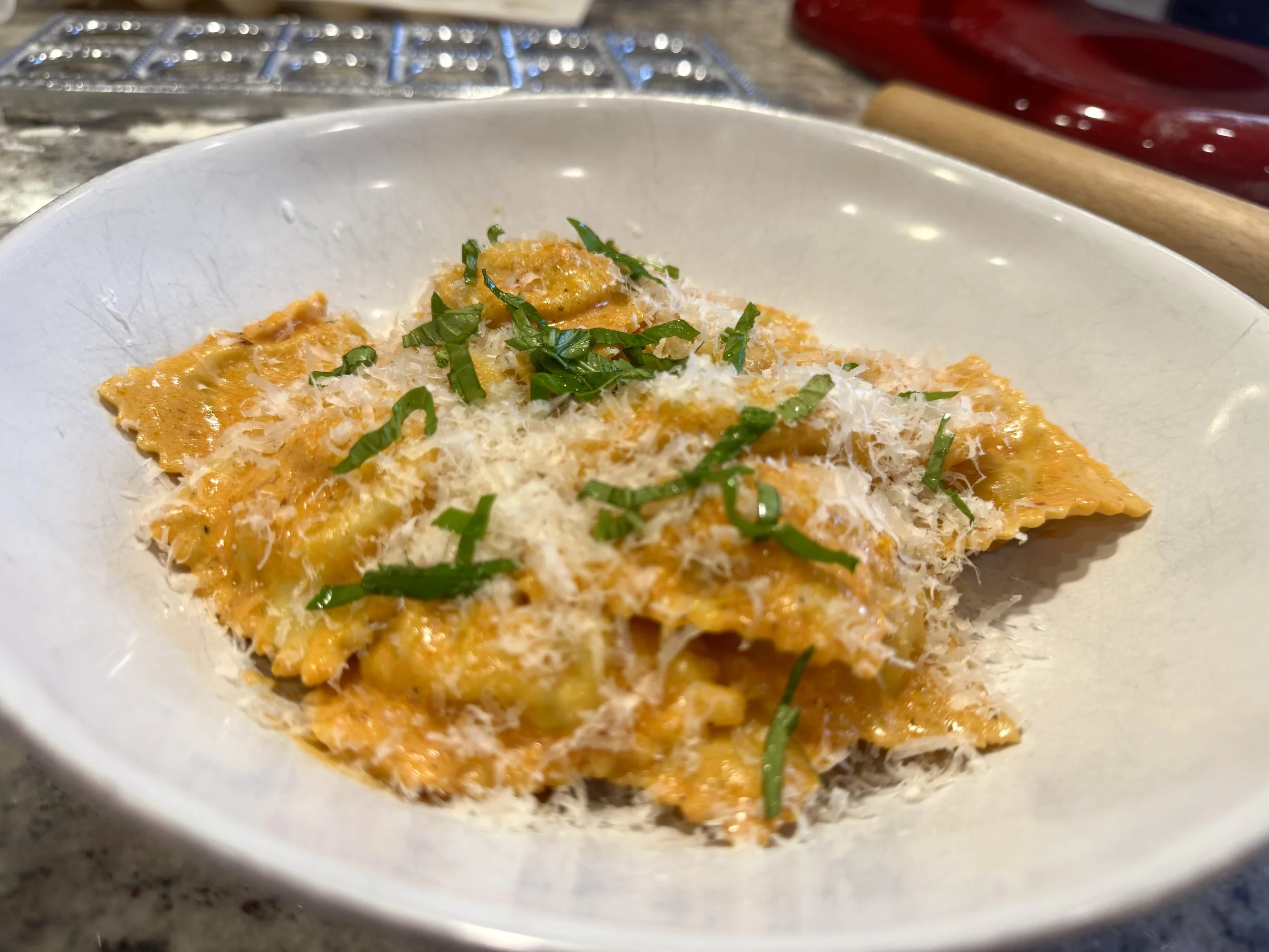 Homemade lobster ravioli plated in tomato cream sauce