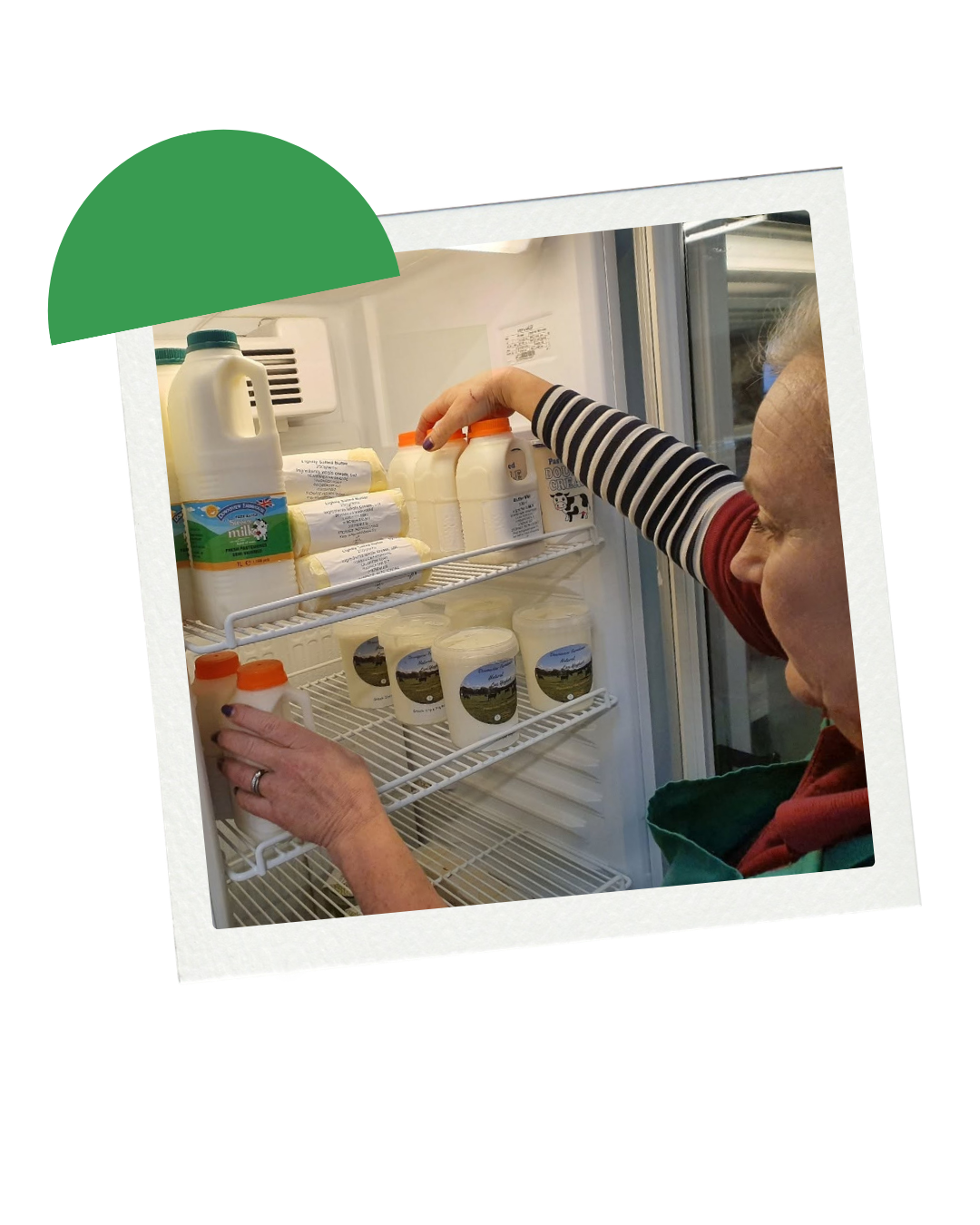 A woman arranging dairy products, including milk bottles and yogurt containers, inside a refrigerator.