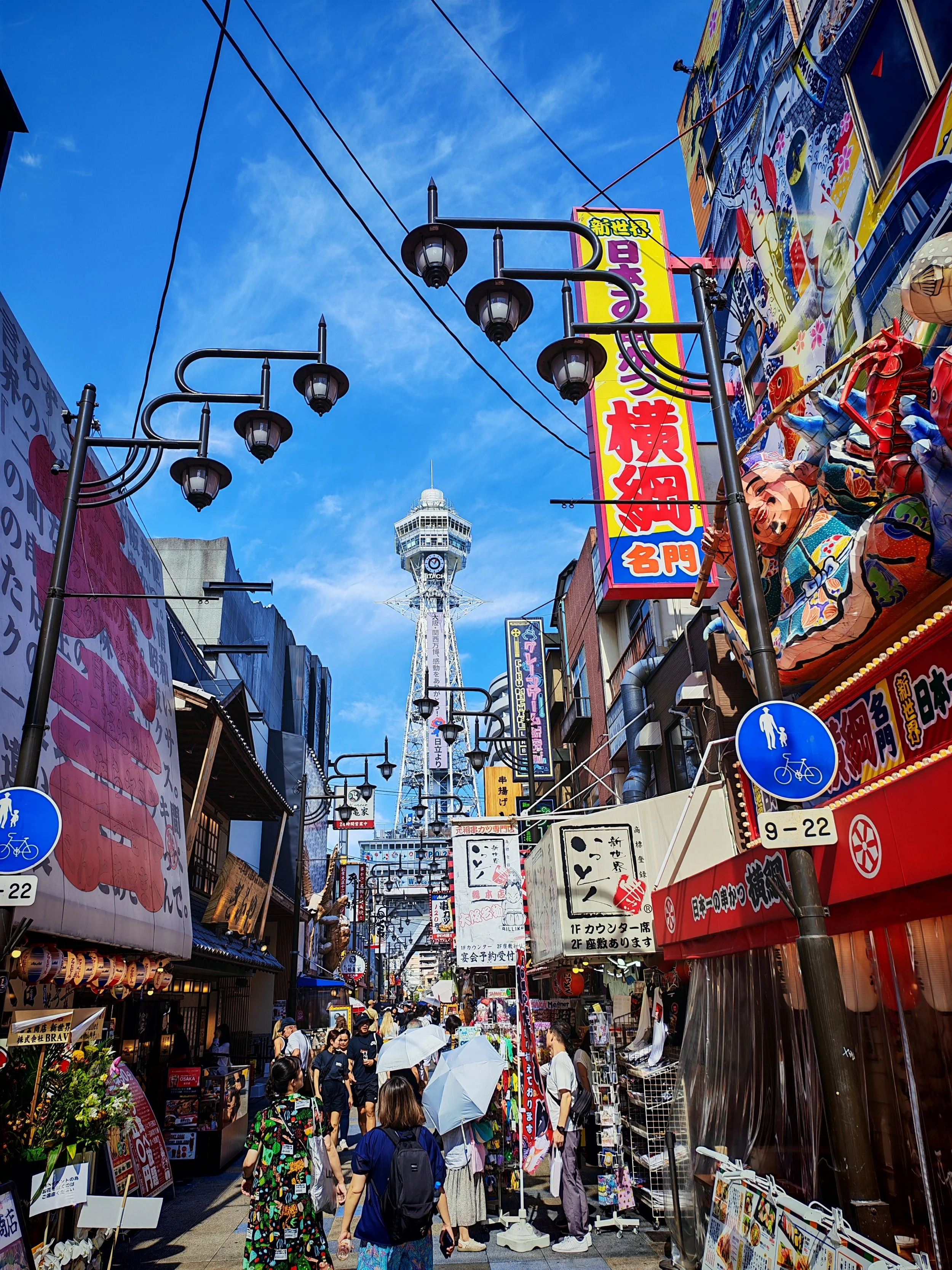 Oszaka retro Shinsekai negyede a Tsutenkaku toronnyal és világító reklámfeliratokkal