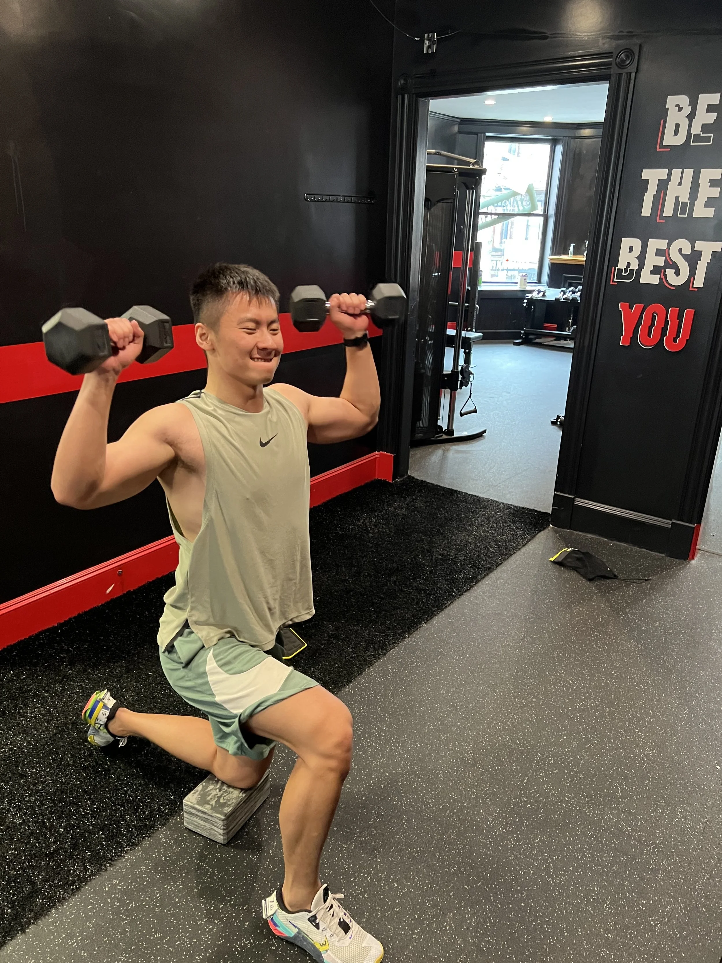 Man In a Half Kneel Lifting Weights