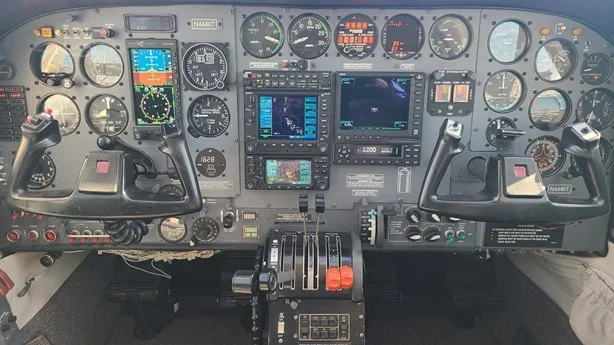 A detailed aircraft cockpit dashboard with multiple gauges, screens, and controls for flight navigation and operation.